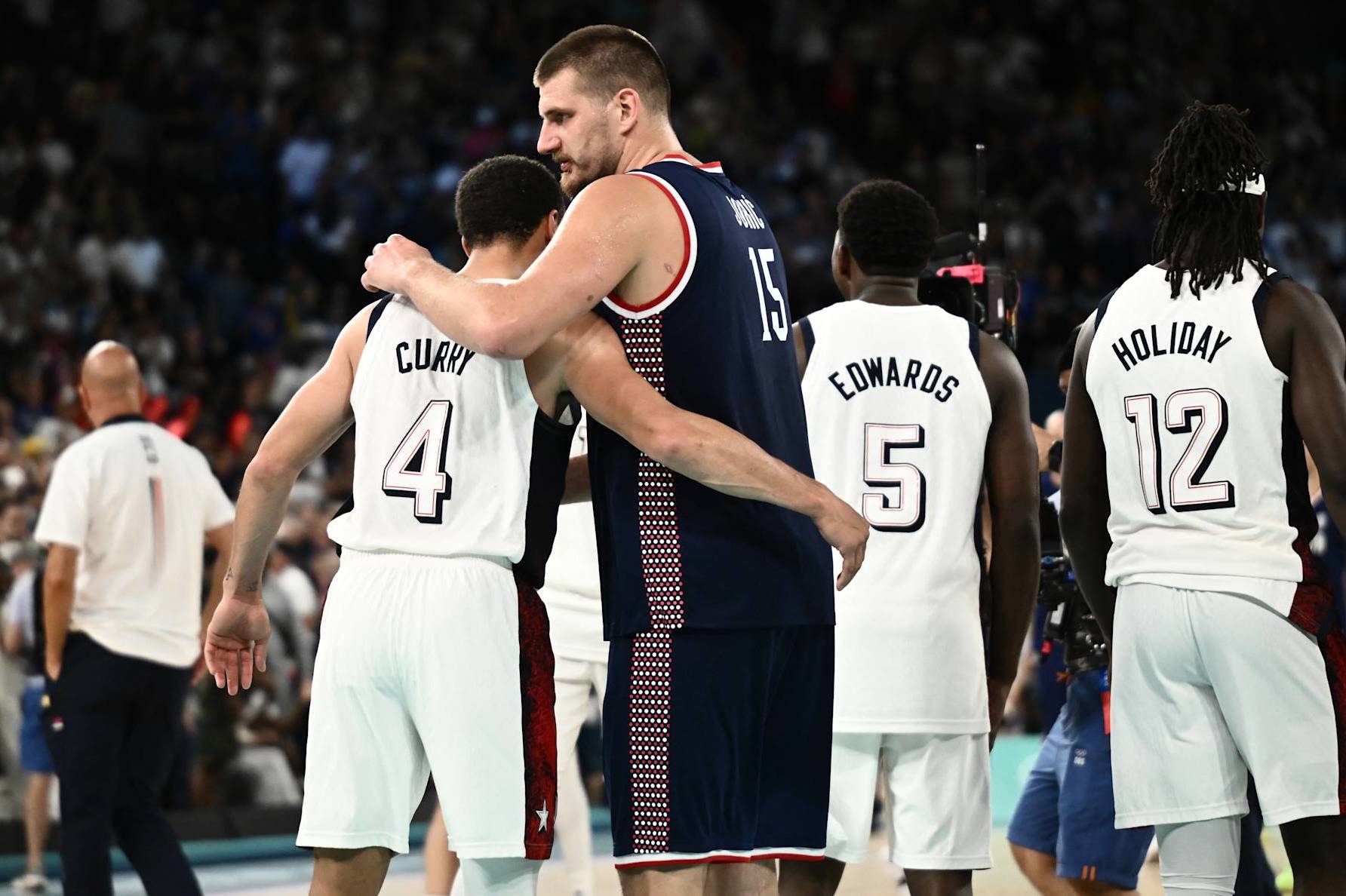 USA's #04 Stephen Curry (L) comforts Serbia's #15 Nikola Jokic at the end of the men's semifinal basketball match between USA and Serbia during the Paris 2024 Olympic Games at the Bercy  Arena in Paris on August 8, 2024. (Photo by Aris MESSINIS / AFP) (Photo by ARIS MESSINIS/AFP via Getty Images)