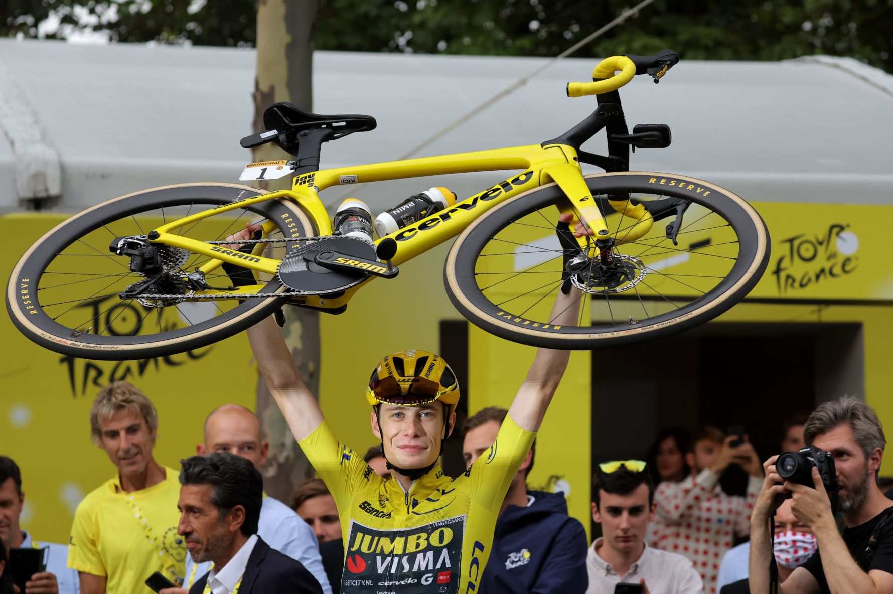 TOPSHOT - Jumbo-Visma's Danish rider Jonas Vingegaard wearing the overall leader's yellow jersey celebrates victory by lifting his bike at the end the 21st and final stage of the 110th edition of the Tour de France cycling race, 115 km between Saint-Quentin-en-Yvelines and the Champs-Elysees in Paris, on July 23, 2023. (Photo by Thomas SAMSON / AFP) (Photo by THOMAS SAMSON/AFP via Getty Images)
