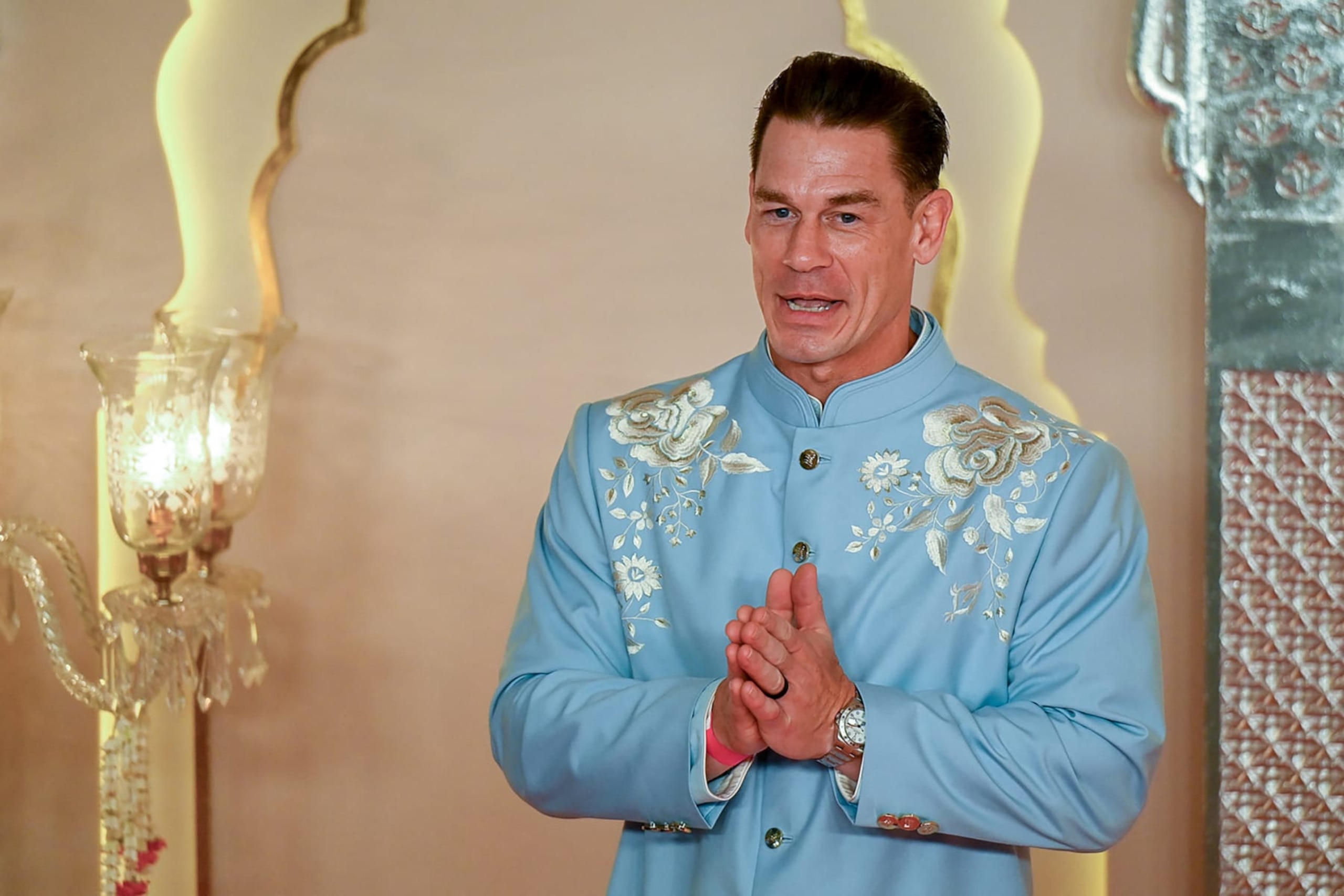 Hollywood actor John Cena gestures as he arrives for the wedding ceremony of billionaire tycoon and Chairman of Reliance Industries Mukesh Ambani's son Anant Ambani and Radhika Merchant in Mumbai on July 12, 2024. Socialite sisters Kim and Khloe Kardashian were among the global celebrities spotted in India on July 12 to attend a lavish three-day wedding ceremony staged by Asia's richest man Mukesh Ambani. (Photo by Punit PARANJPE / AFP) (Photo by PUNIT PARANJPEPUNIT PARANJPE/AFP via Getty Images)