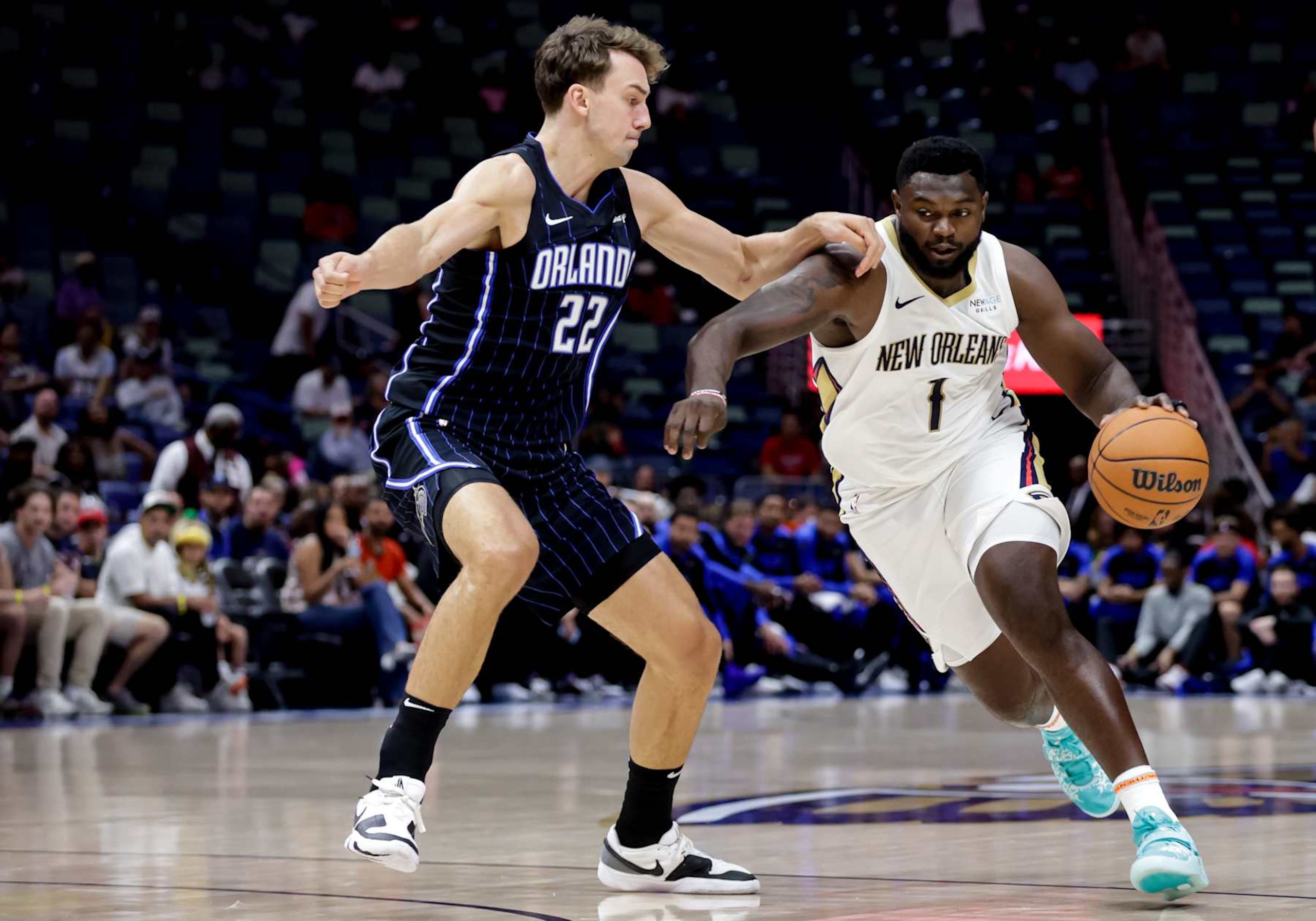 NEW ORLEANS, LOUISIANA - OCTOBER 7:  Zion Williamson #1 of the New Orleans Pelicans drives past Franz Wagner #22 of the Orlando Magic during the first half of a preseason game at the Smoothie King Center on October 7, 2024 in New Orleans, Louisiana. NOTE TO USER: User expressly acknowledges and agrees that, by downloading and or using this photograph, User is consenting to the terms and conditions of the Getty Images License Agreement. (Photo by Derick E. Hingle/Getty Images)