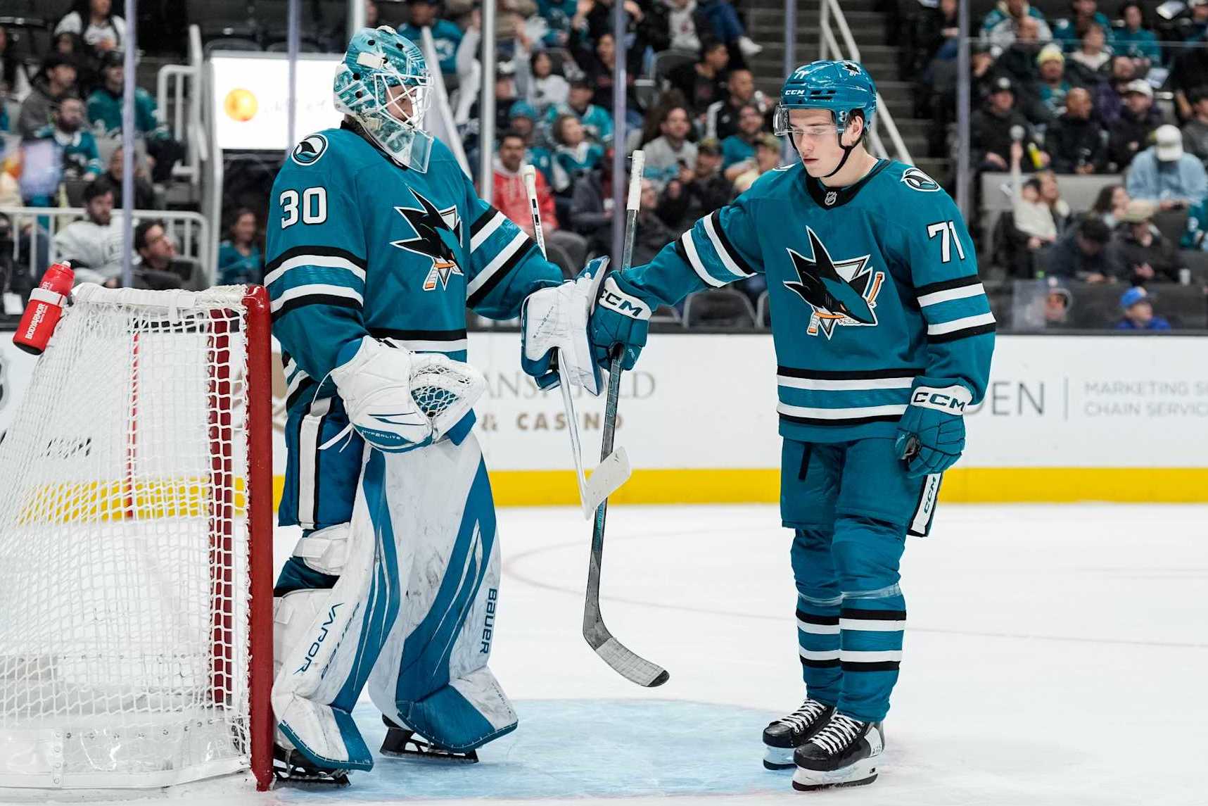 SAN JOSE, CALIFORNIA - NOVEMBER 25: Macklin Celebrini #71 of the San Jose Sharks high-fives goaltender Yaroslav Askarov #30 against the Los Angeles Kings at SAP Center on November 25, 2024 in San Jose, California. (Photo by Andreea Cardani/NHLI via Getty Images)