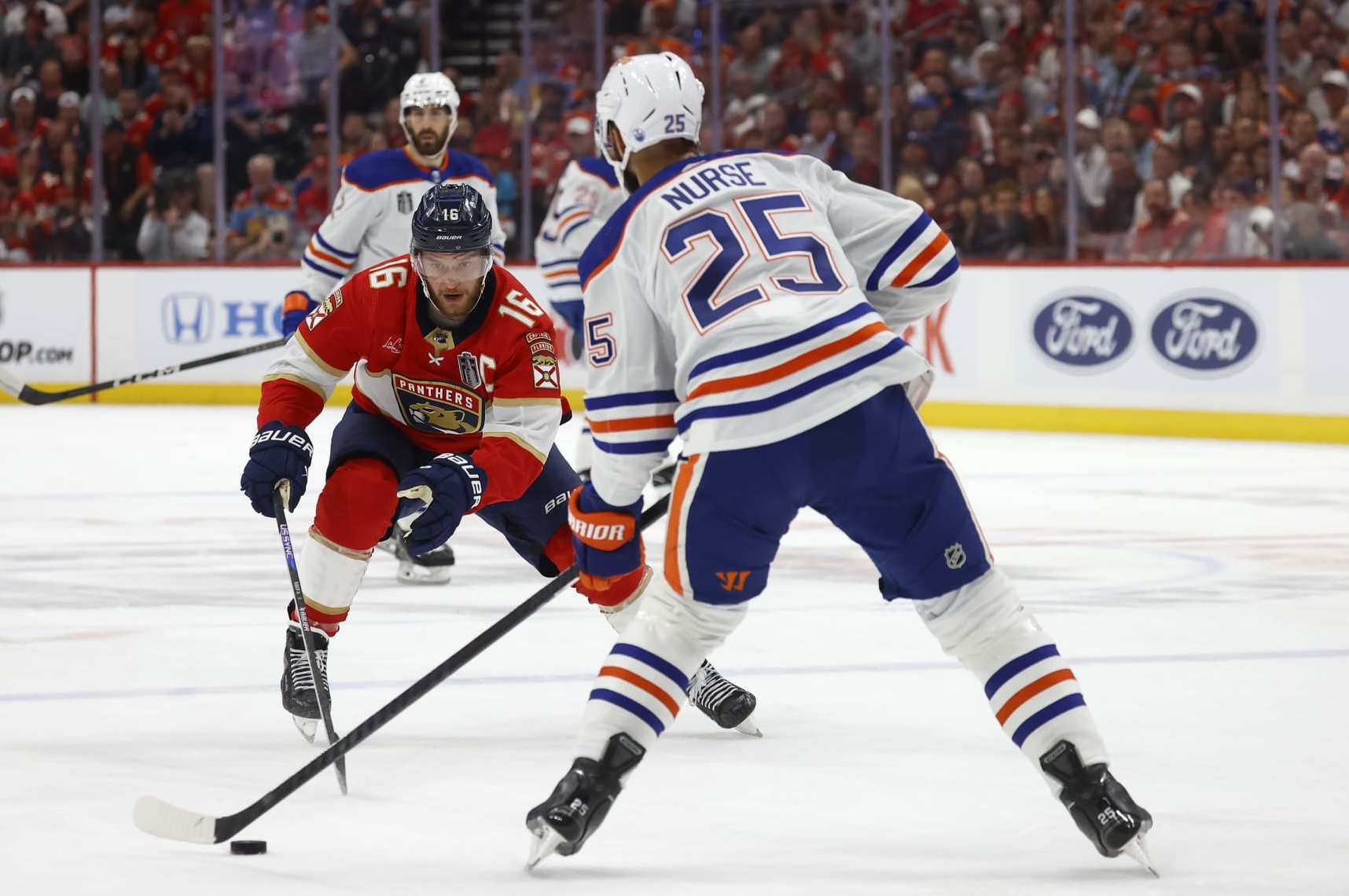SUNRISE, FLORIDA - JUNE 8: Darnell Nurse #25 of the Edmonton Oilers looks to pass against Aleksander Barkov #16 of the Florida Panthers in Game One of the Stanley Cup Final at the Amerant Bank Arena on June 8, 2024 in Sunrise, Florida. (Photo by Eliot J. Schechter/NHLI via Getty Images)