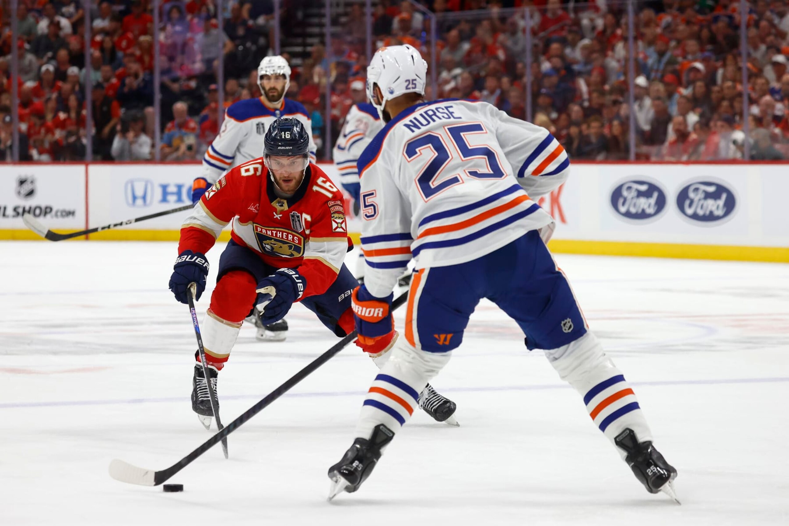 SUNRISE, FLORIDA - JUNE 8: Darnell Nurse #25 of the Edmonton Oilers looks to pass against Aleksander Barkov #16 of the Florida Panthers in Game One of the Stanley Cup Final at the Amerant Bank Arena on June 8, 2024 in Sunrise, Florida. (Photo by Eliot J. Schechter/NHLI via Getty Images)