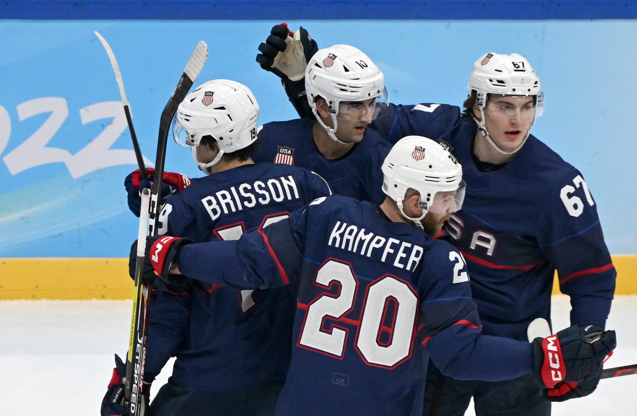 USA's Brendan Brisson (L) celebrates with teammates after scoring a goal against China during the men's preliminary round group A match of the Beijing 2022 Winter Olympic Games ice hockey competition, at the National Indoor Stadium in Beijing on February 10, 2022. (Photo by ANTHONY WALLACE / AFP) (Photo by ANTHONY WALLACE/AFP via Getty Images)