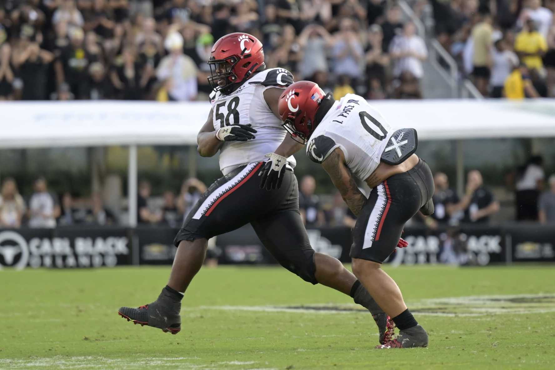 Cincinnati defensive lineman Dontay Corleone (58) and linebacker Ivan Pace Jr. (0) celebrate after Corleone recovered a fumble during the second half of an NCAA college football game against Central Florida, Saturday, Oct. 29, 2022, in Orlando, Fla. (AP Photo/Phelan M. Ebenhack)