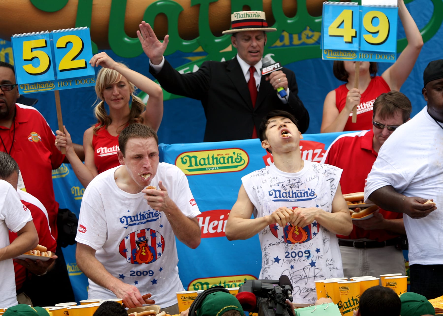 NEW YORK - JULY 4:  Joey Chestnut of San Jose, California (C) and Takeru Kobayashi of Nagano, Japan (R) stuff hot dogs into their mouths during Nathan's Famous Fourth of July hot dog eating contest on July 4, 2009 in Coney Island in the Brooklyn borough of New York City.  Chestnut defeated Kobayashi with eating 68 to his 64.5 hotdogs. Kobayashi won six previous competitions before tying last year with Chestnut. (Photo by Yana Paskova/Getty Images)