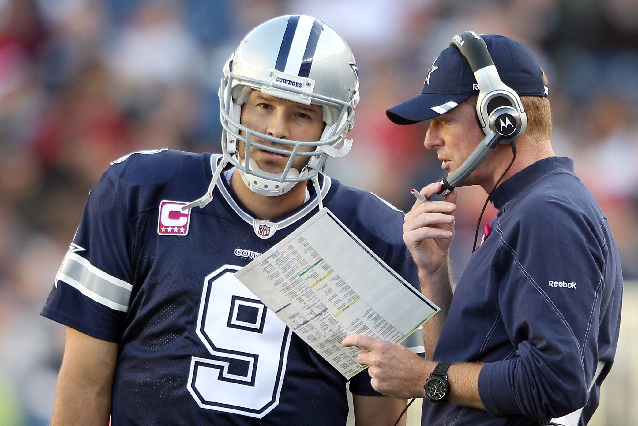 FOXBORO, MA - OCTOBER 16: Tony Romo #9 of the Dallas Cowboys talks with head coach Jason Garrett in the first half against the New England Patriots on October 16, 2011 at Gillette Stadium in Foxboro, Massachusetts. (Photo by Elsa/Getty Images)