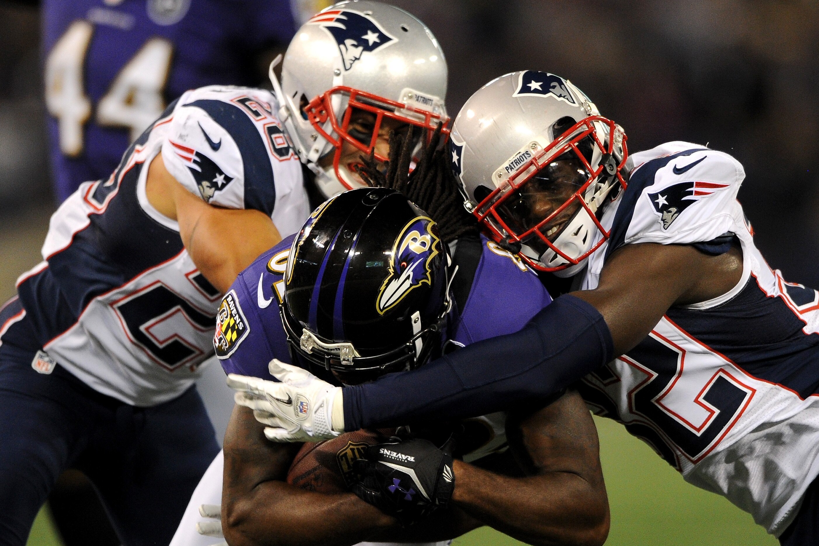 BALTIMORE, MD - SEPTEMBER 23: Torrey Smith (C) #82 of the Baltimore Ravens is tackled by Steve Gregory #28 and Devin McCourty #32 (R) of the New England Patriots at M&T Bank Stadium on September 23, 2012 in Baltimore, Maryland. (Photo by Patrick Smith/Getty Images)