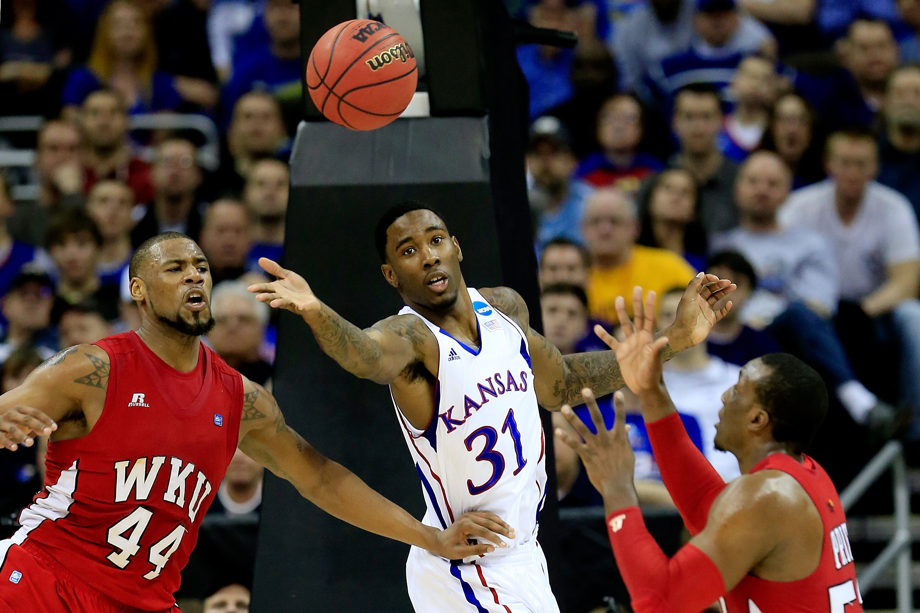 KANSAS CITY, MO - MARCH 22: Jamari Traylor #31 of the Kansas Jayhawks fights for the ball against George Fant #44 and T.J. Price #52 of the Western Kentucky Hilltoppers in the first half during the second round of the 2013 NCAA Men's Basketball Tournament at the Sprint Center on March 22, 2013 in Kansas City, Missouri. (Photo by Jamie Squire/Getty Images)