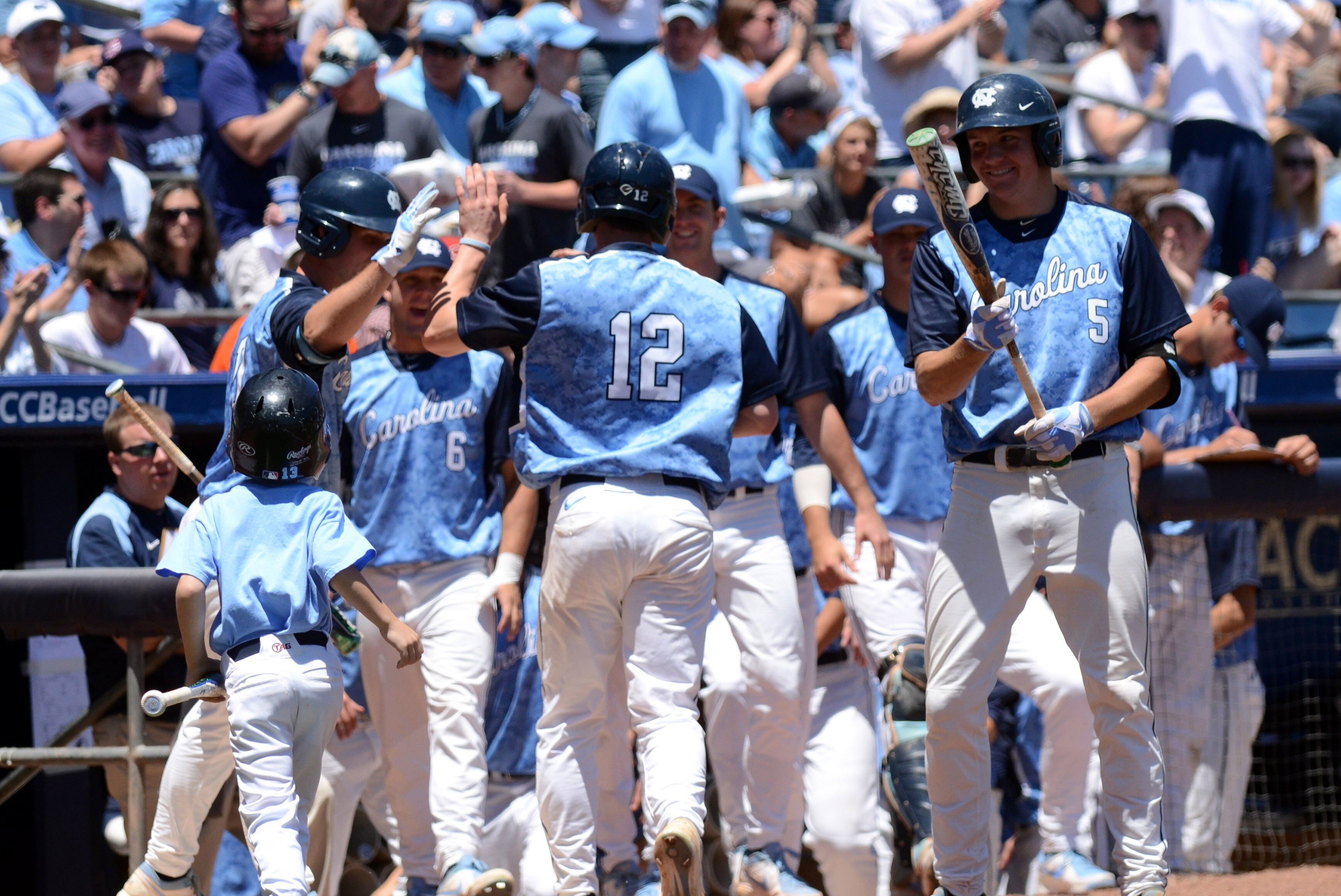 May 26, 2013; Durham, NC, USA; North Carolina Tar Heels designated hitter Landon Lassiter (12) is congratulated by teammates after scoring a run against the Virginia Tech Hokies during the ACC baseball tournament at Durham Bulls Athletic Park. Mandatory Credit: Rob Kinnan-USA TODAY Sports