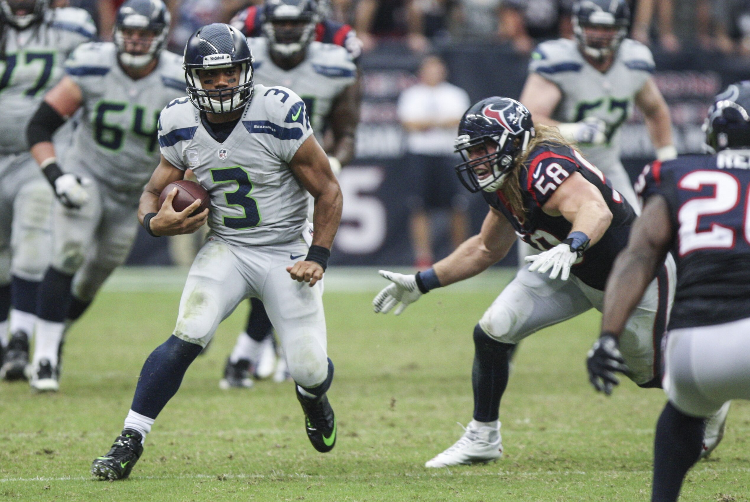Sep 29, 2013; Houston, TX, USA; Seattle Seahawks quarterback Russell Wilson (3) runs with the ball during overtime as Houston Texans outside linebacker Brooks Reed (58) attempts to make a tackle at Reliant Stadium. The Seahawks defeated the Texans 23-20. Mandatory Credit: Troy Taormina-USA TODAY Sports
