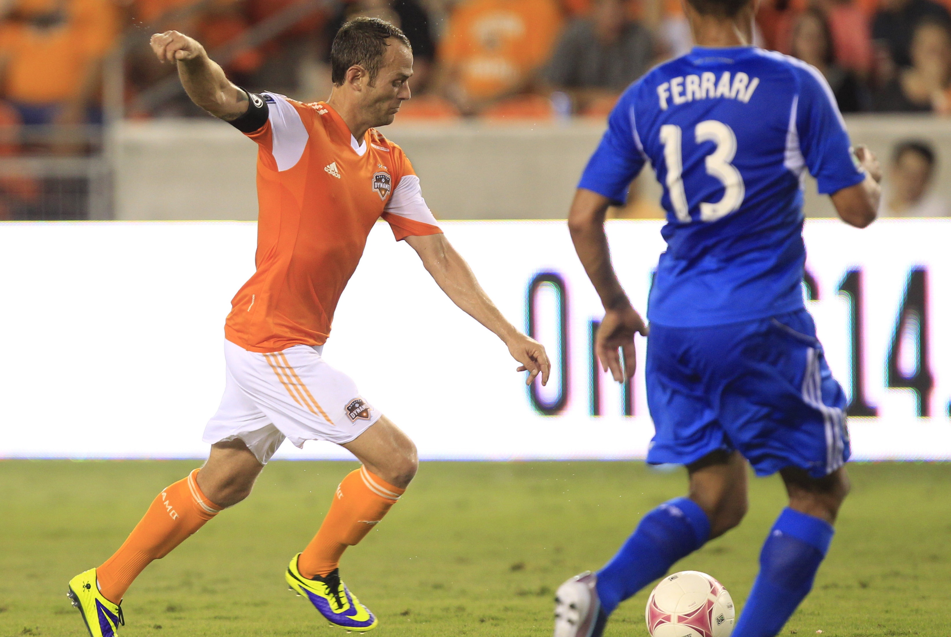 Oct 4, 2013; Houston, TX, USA; Houston Dynamo midfielder Brad Davis (11) shoots against Montreal Impact defender Matteo Ferrari (13) during the second half at BBVA Compass Stadium. The Dynamo won 1-0. Mandatory Credit: Thomas Campbell-USA TODAY Sports