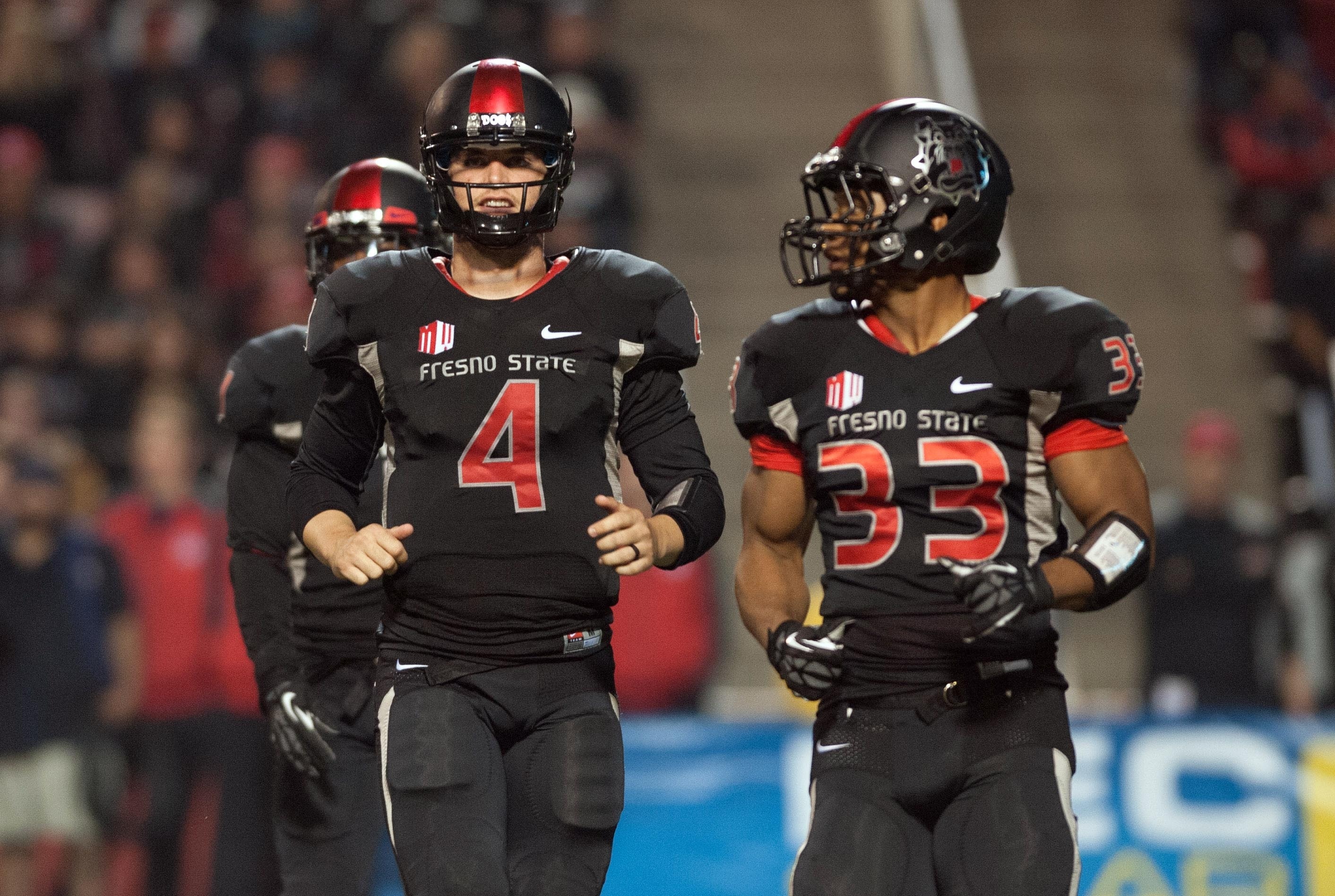 Nov 2, 2013; Fresno, CA, USA; Fresno State Bulldogs quarterback Derek Carr (4) and running back Marteze Waller (33) jog onto the field after a turnover during the third quarter of the game against the Nevada Wolf Pack at Bulldog Stadium. Fresno State won 41-23. Mandatory Credit: Ed Szczepanski-USA TODAY Sports