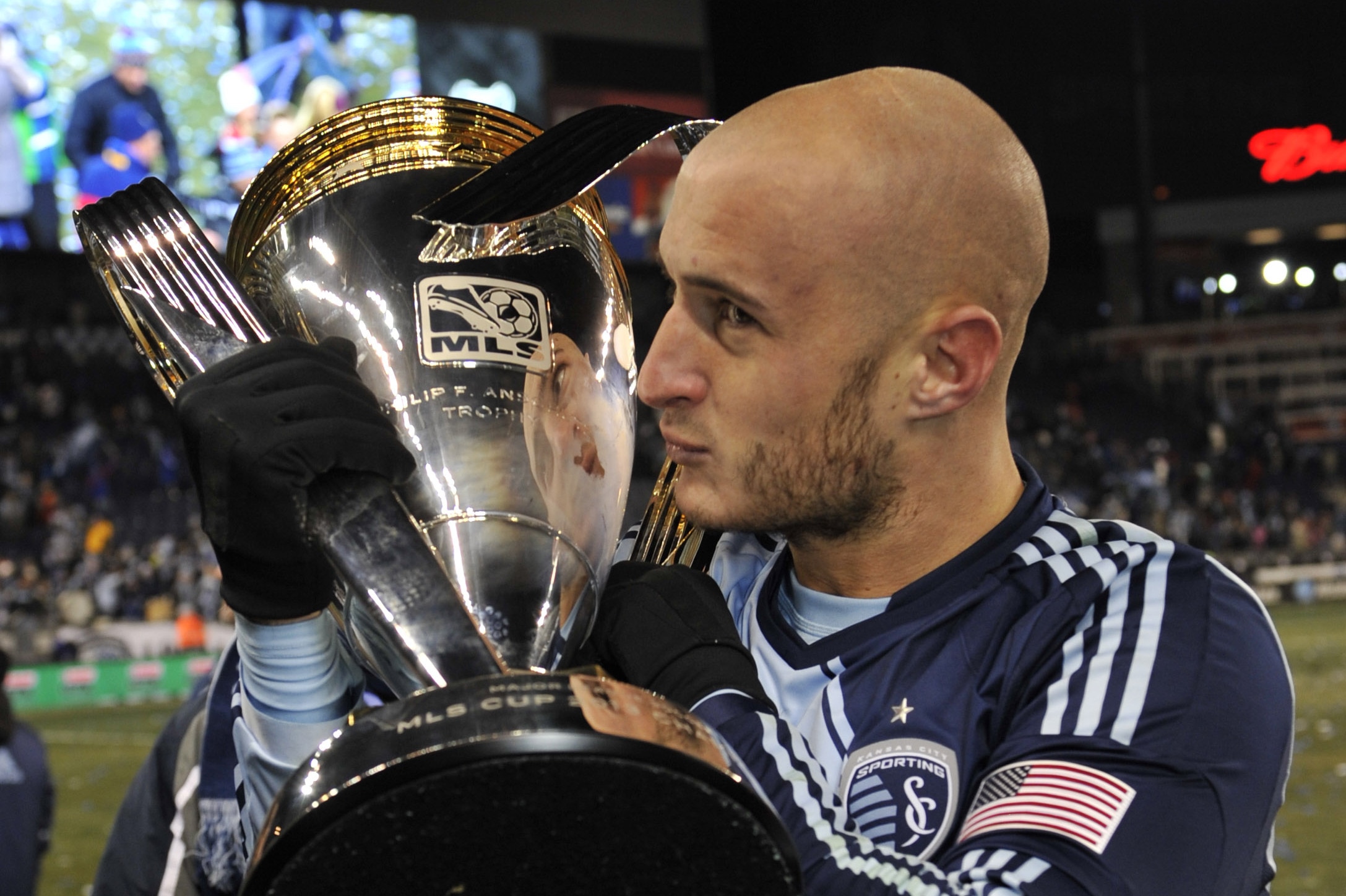 Dec 7, 2013; Kansas City, KS, USA; Sporting KC defender Aurelien Collin (78) kisses the championship trophy after the 2013 MLS Cup against the Real Salt Lake at Sporting Park. Sporting KC won in a shootout. Mandatory Credit: Peter G. Aiken-USA TODAY Sports