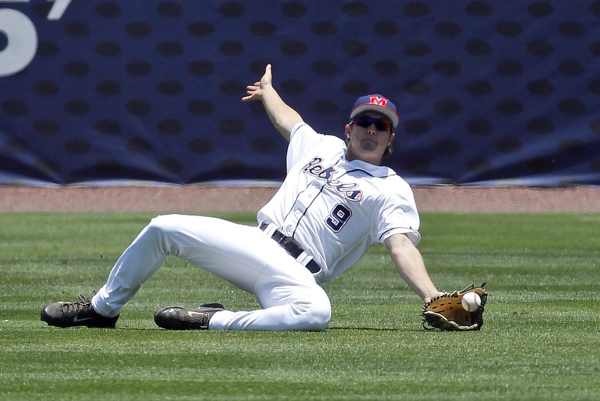 Mississippi's Auston Bousfield (9) tries unsuccessfully to catch a fly ball as he slides during the first inning at the Southeastern Conference NCAA college baseball tournament on Wednesday, May 21, 2014, in Hoover, Ala. (AP Photo/Butch Dill)