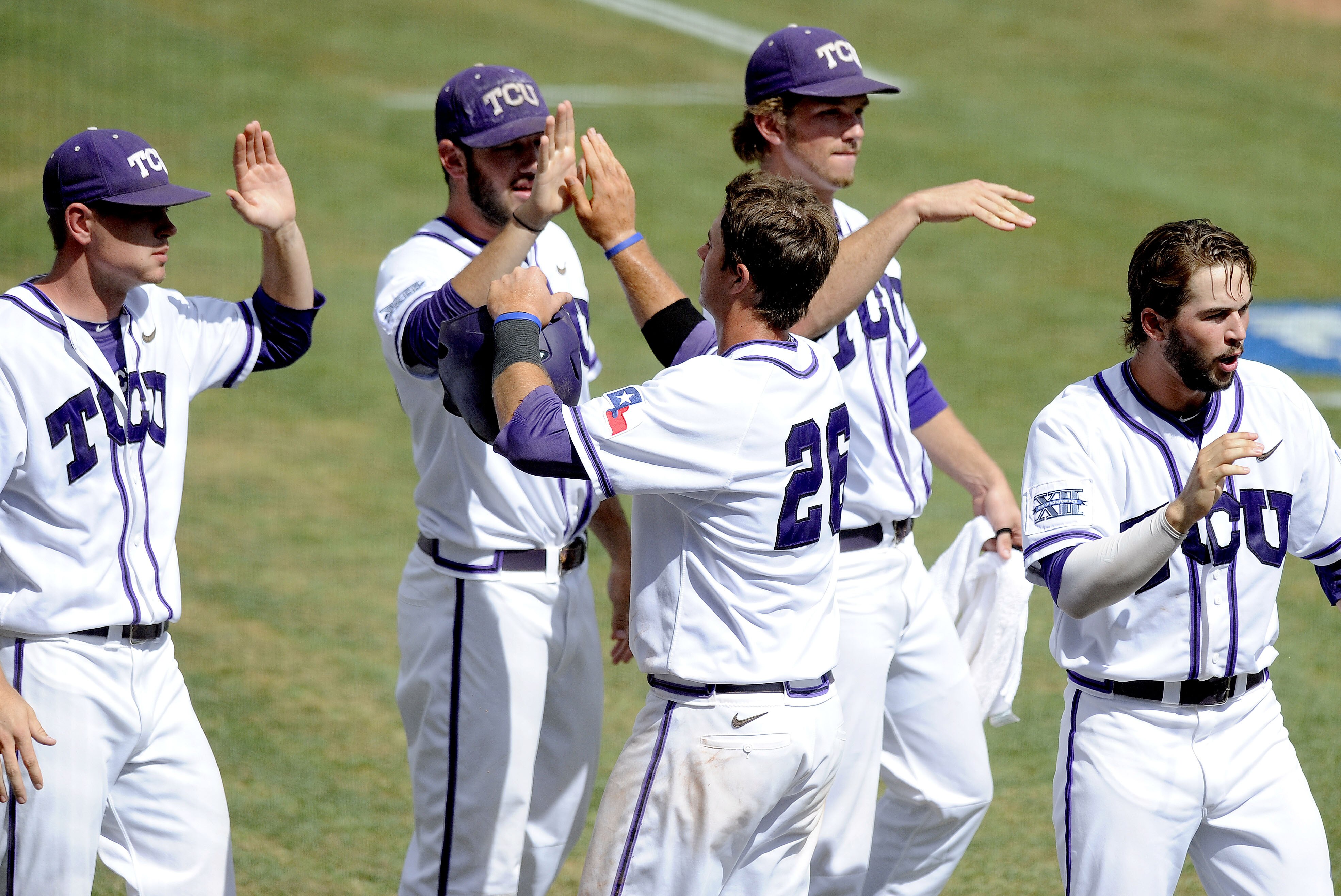 TCU infielder Keaton Jones (26) is congratulated by teammates after scoring a run in the fourth inning of an NCAA college baseball tournament super regional game against Pepperdine in Fort Worth, Saturday, June 7, 2014. (AP Photo/Matt Strasen)