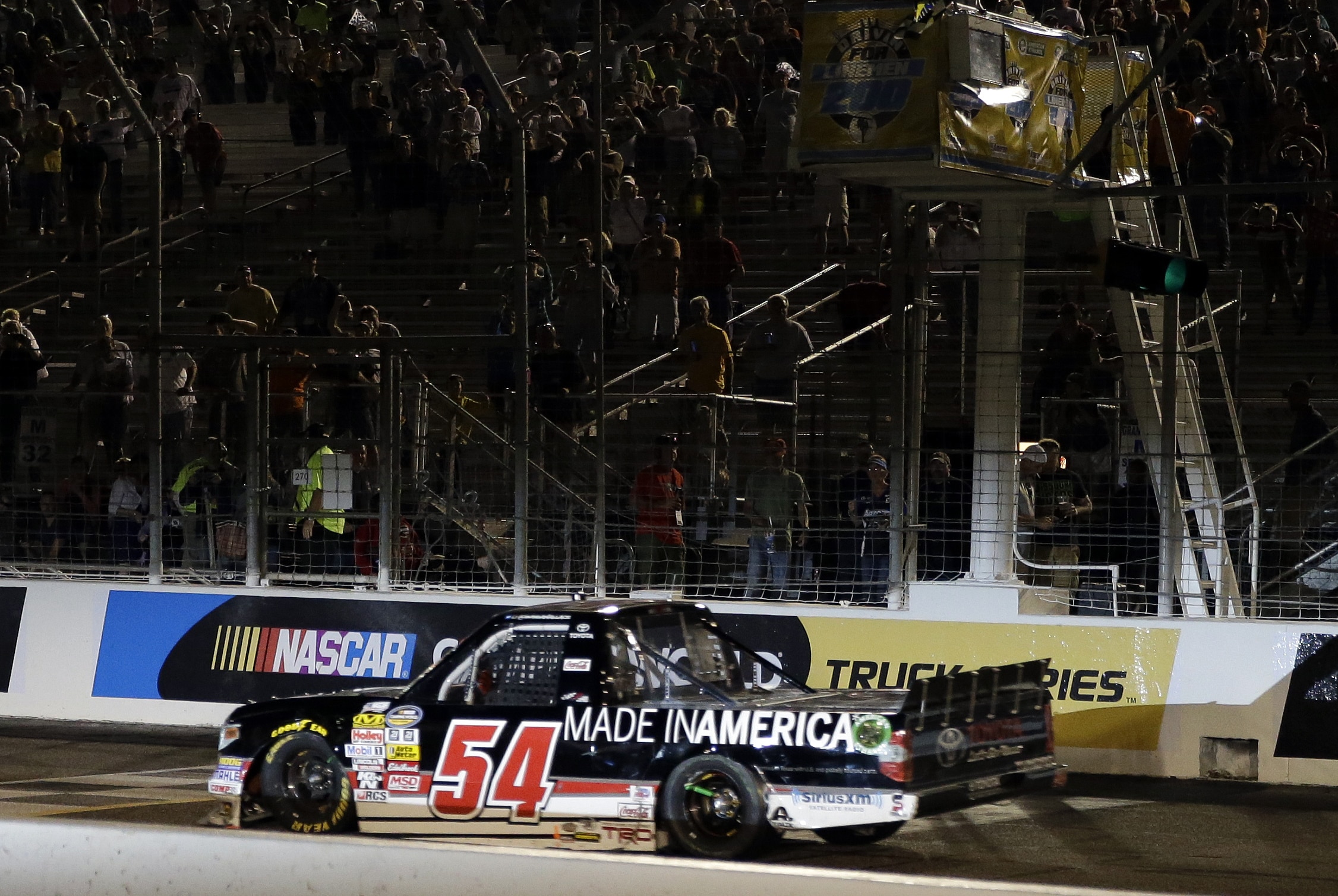 Darrell Wallace Jr. takes the checkered flag to win the NASCAR Truck Series auto race at Gateway Motorsports Park on Saturday, June 14, 2014, in Madison, Ill. (AP Photo/Jeff Roberson)