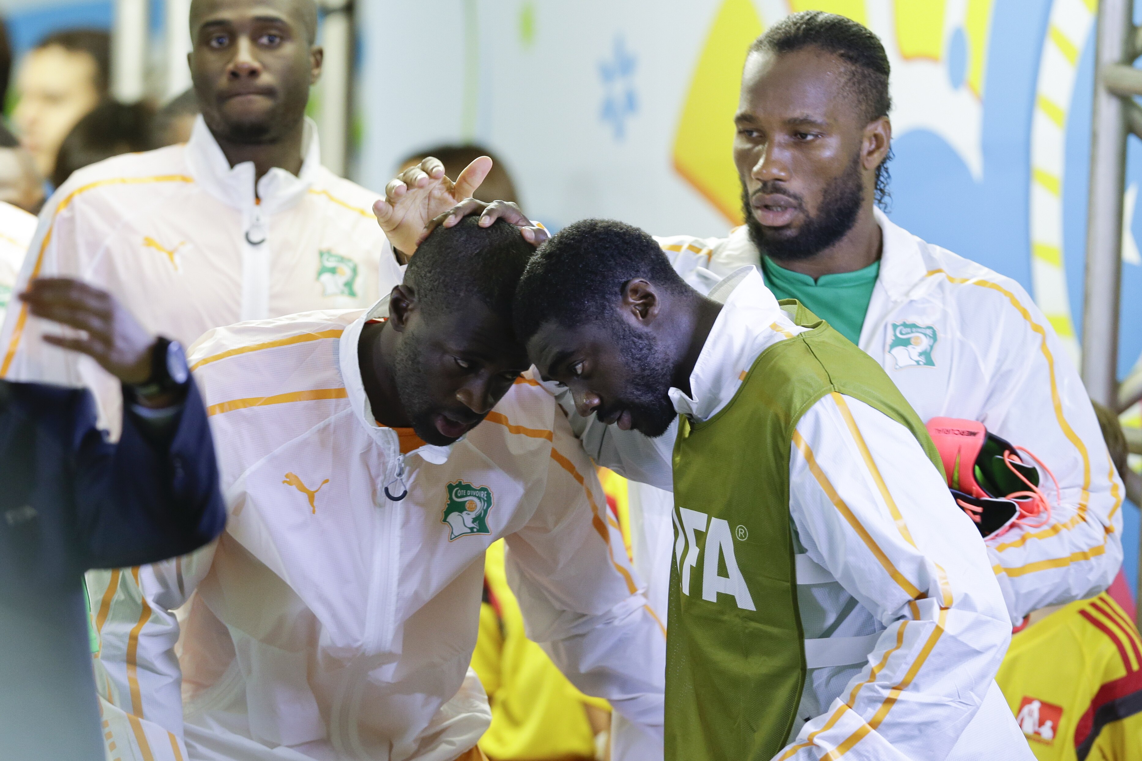 Ivory Coast's Kolo Toure and Yaya Toure, left, greet each other as Didier Drogba watches before the group C World Cup soccer match between Ivory Coast and Japan at the Arena Pernambuco in Recife, Brazil, Saturday, June 14, 2014. (AP Photo/Ricardo Mazalan)