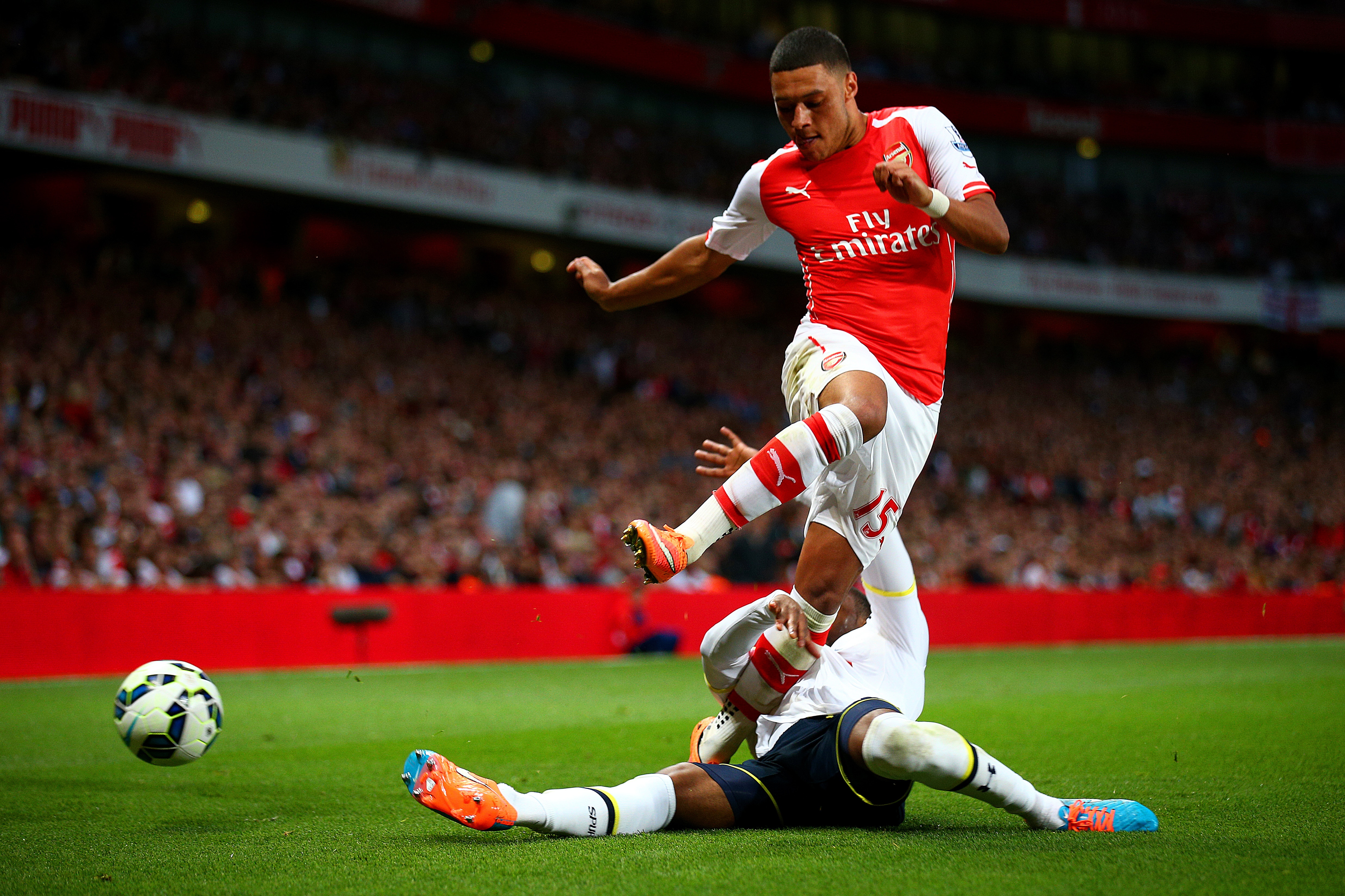 LONDON, ENGLAND - SEPTEMBER 27: Danny Rose of Spurs tackles Alex Oxlade-Chamberlain of Arsenal during the Barclays Premier League match between Arsenal and Tottenham Hotspur at Emirates Stadium on September 27, 2014 in London, England. (Photo by Paul Gilham/Getty Images)