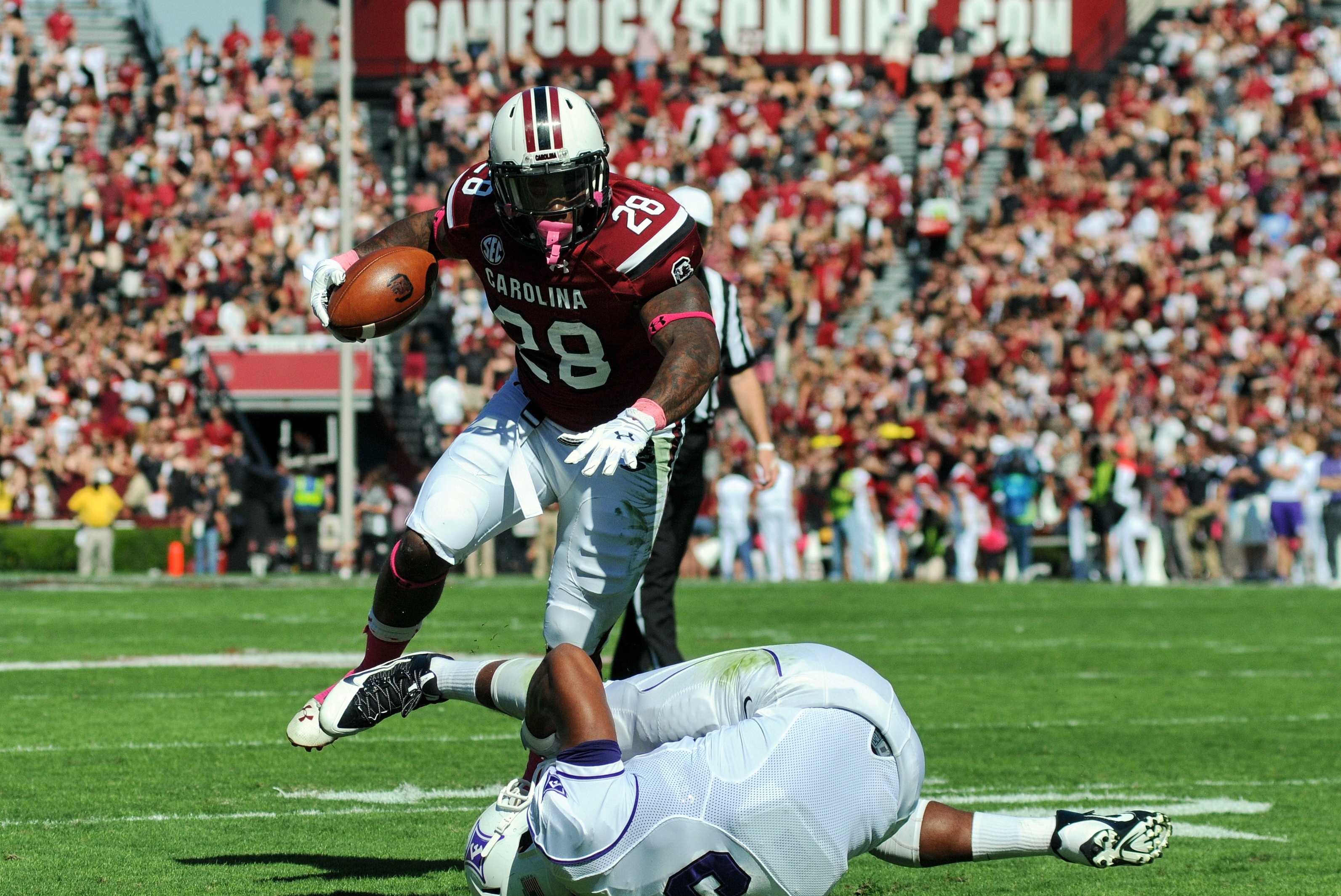 South Carolina running back Mike Davis (28) jumps over Furman's Gary Wilkins on his way to the end zone for a first half touchdown during an NCAA college football game in Columbia, S.C., Saturday, Oct. 18, 2014. (AP Photo/ Richard Shiro)