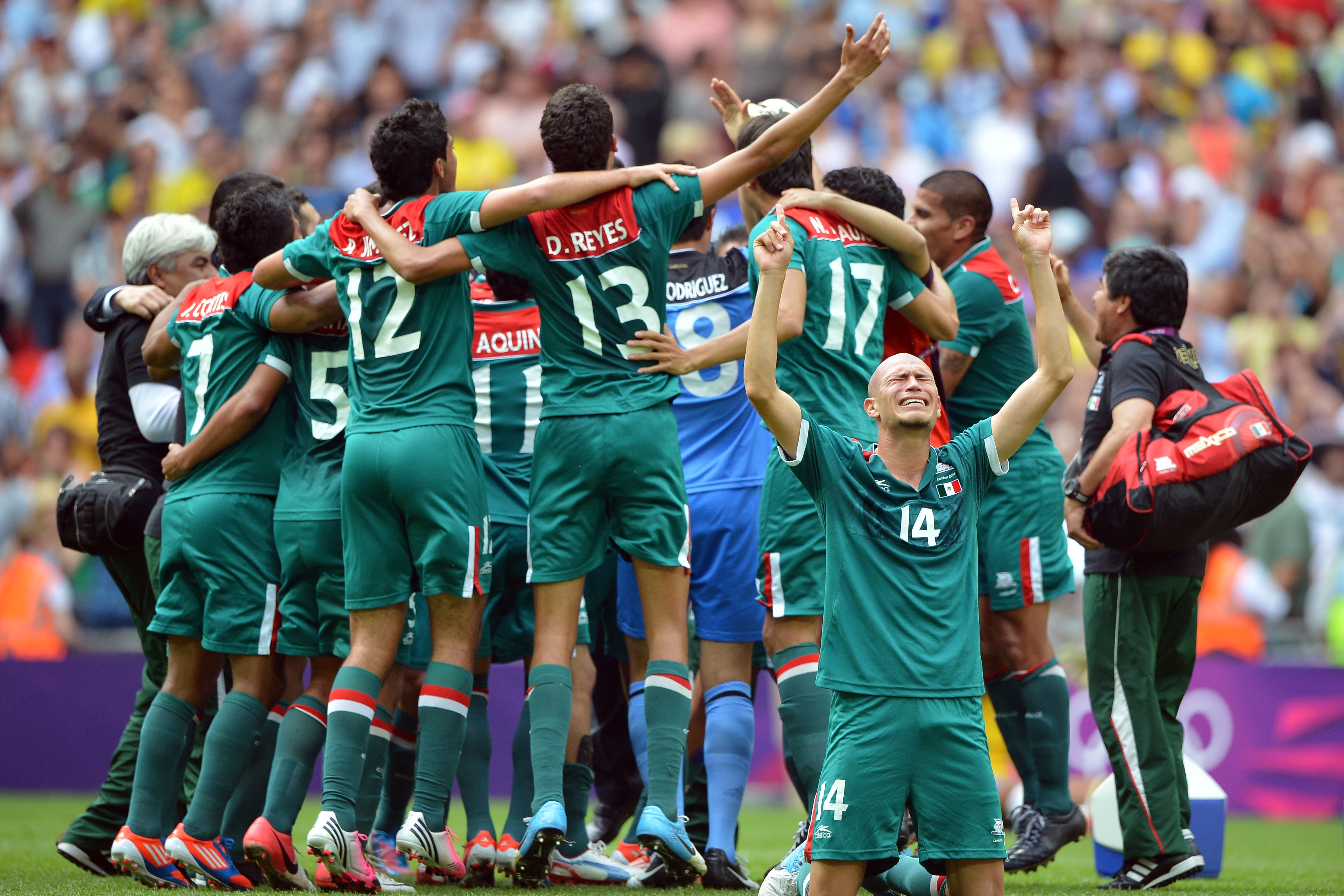 LONDON, ENGLAND - AUGUST 11: Jorge Enriquez of Mexico falls to the ground with jubilation as team-mates celebrate winning the gold medal after the Men's Football Final between Brazil and Mexico on Day 15 of the London 2012 Olympic Games at Wembley Stadium on August 11, 2012 in London, England. (Photo by Jeff J Mitchell/Getty Images)