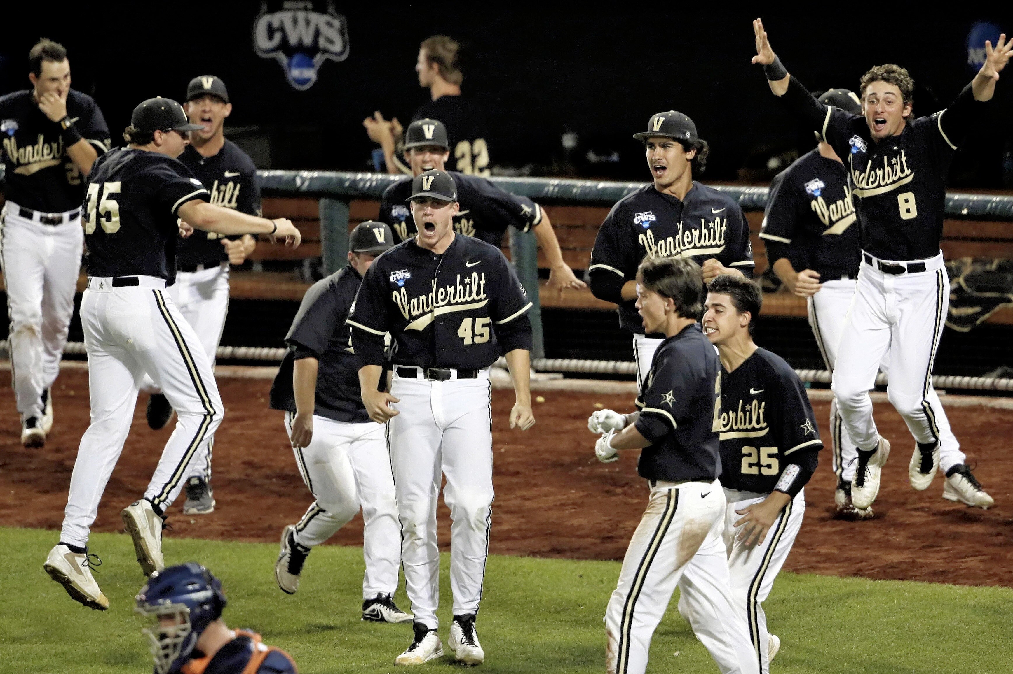 FILE- In this June 25, 2014, file photo, Vanderbilt players celebrate after a home run by John Norwood, not seen, in the eighth inning against Virginia in Game 3 of the best-of-three NCAA baseball College World Series finals in Omaha, Neb. The home run is back in college baseball thanks to the new flat-seam ball put into play this year, but officials are anxious about whether the trend will continue in the College World Series. In the four years the CWS has been played at the cavernous TD Ameritrade Park, only 25 home runs have been hit in 59 games. Just three were hit each of the last two years, and per-team scoring dipped to three runs a game. (AP Photo/Nati Harnik, file)