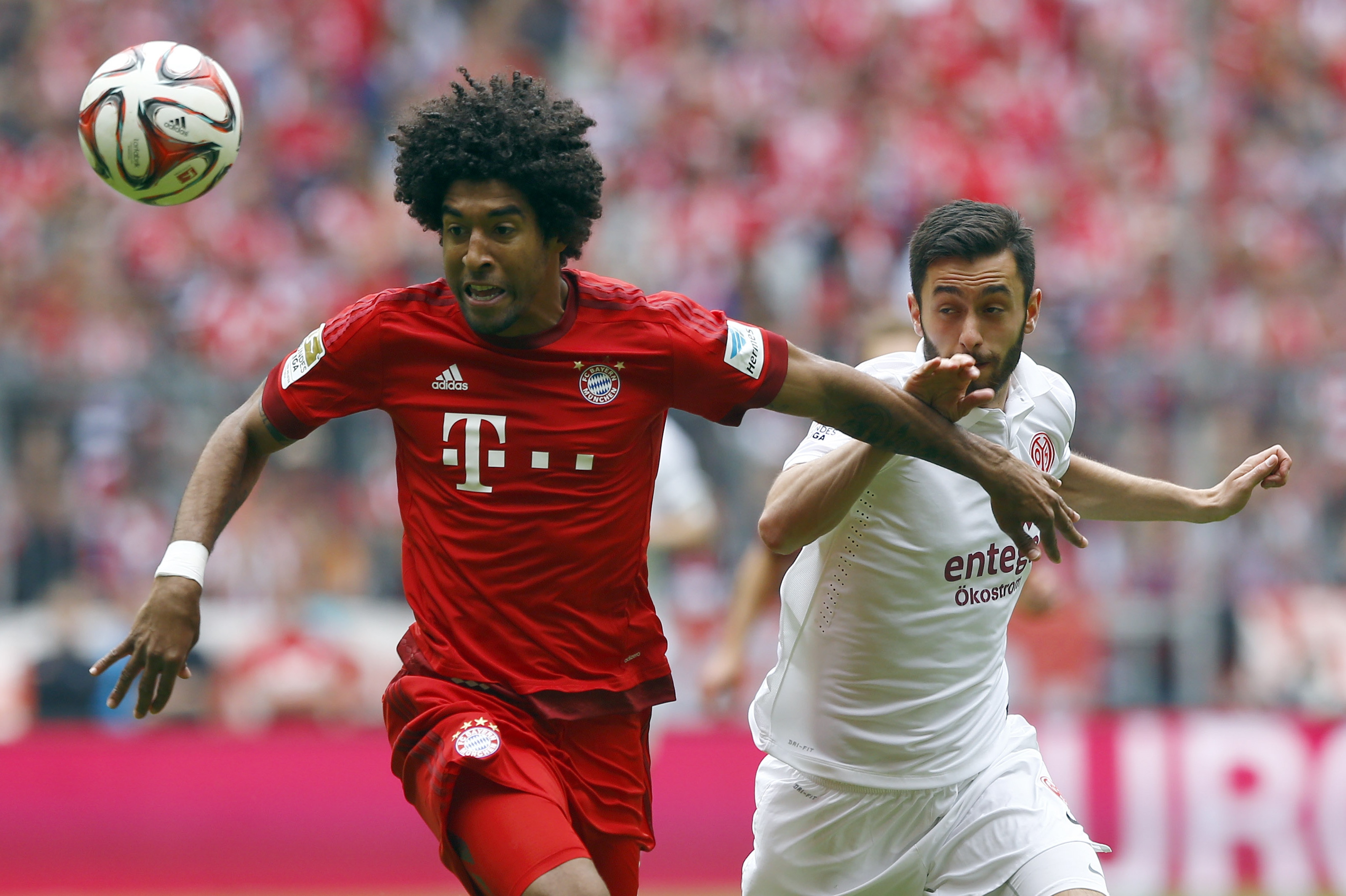 Bayern's Dante from Brazil, left, and Mainz's Yunus Malli challenge for the ball during the German first division Bundesliga soccer match between FC Bayern Munich and 1. FSV Mainz 05 at the Allianz Arena in Munich, Germany, on Saturday, May 23, 2015. (AP Photo/Matthias Schrader)