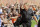 FILE - In this Aug. 15, 2014, file photo, former NFL coach and current ESPN analyst Jon Gruden greets fans at the Cleveland Browns football training camp in Berea, Ohio. The future of youth sports makes Jon Gruden cringe. The Super Bowl-winning coach and ESPN football analyst is part of a program aimed at repairing fields and buying uniforms and equipment. More needs to be done, Gruden says, particularly in low-income areas.  (AP Photo/Mark Duncan, File)