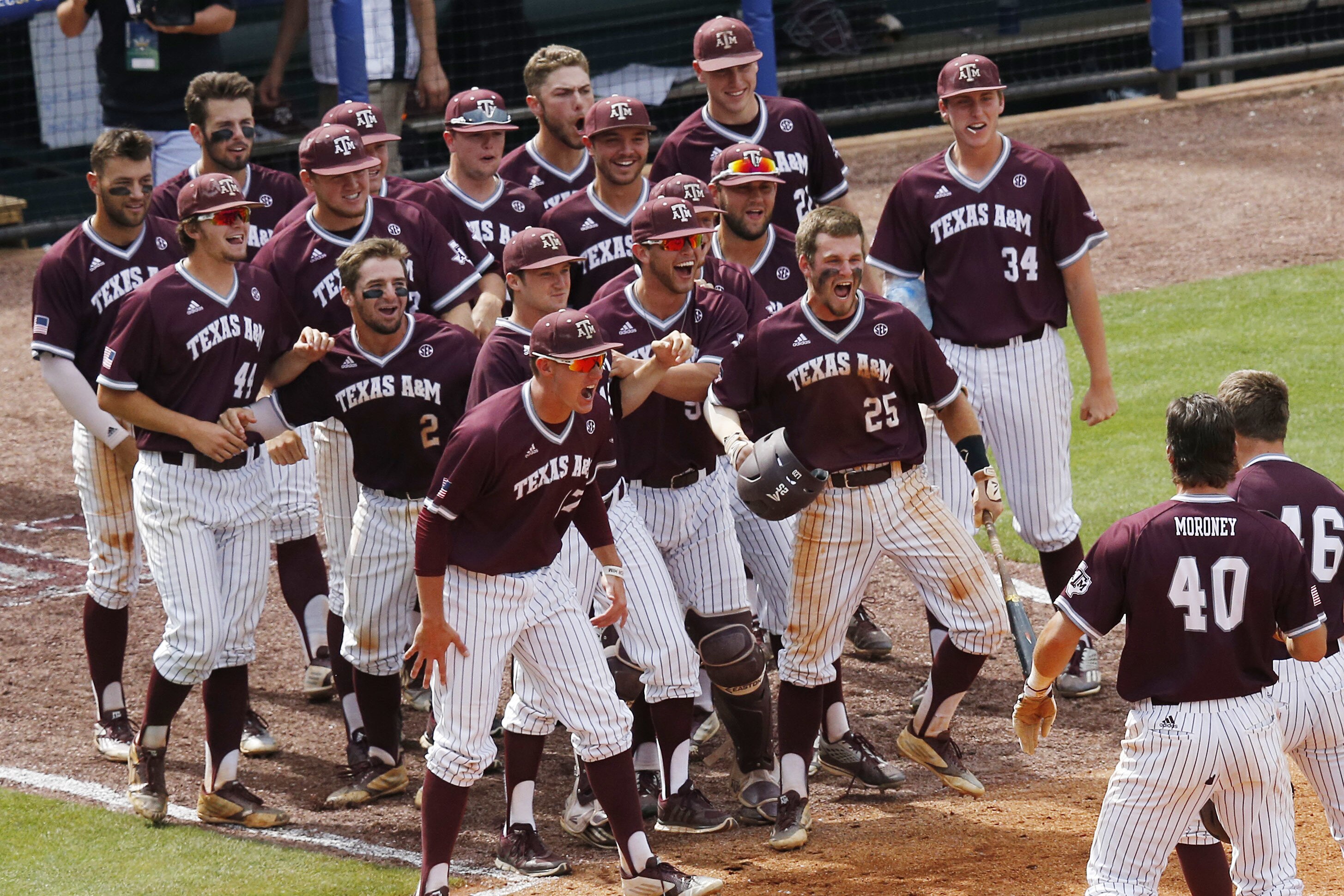 Texas A&M's Walker Pennington, lower right, is welcomed by teammates after Pennington hit a grand slam during the eighth inning of a Southeastern Conference NCAA college baseball tournament game against Mississippi at the Hoover Met, Saturday, May 28, 2016, in Hoover, Ala. (AP Photo/Brynn Anderson)