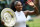 Serena Williams waves to the crowd while showing off the 2016 Wimbledon ladies' singles trophy.