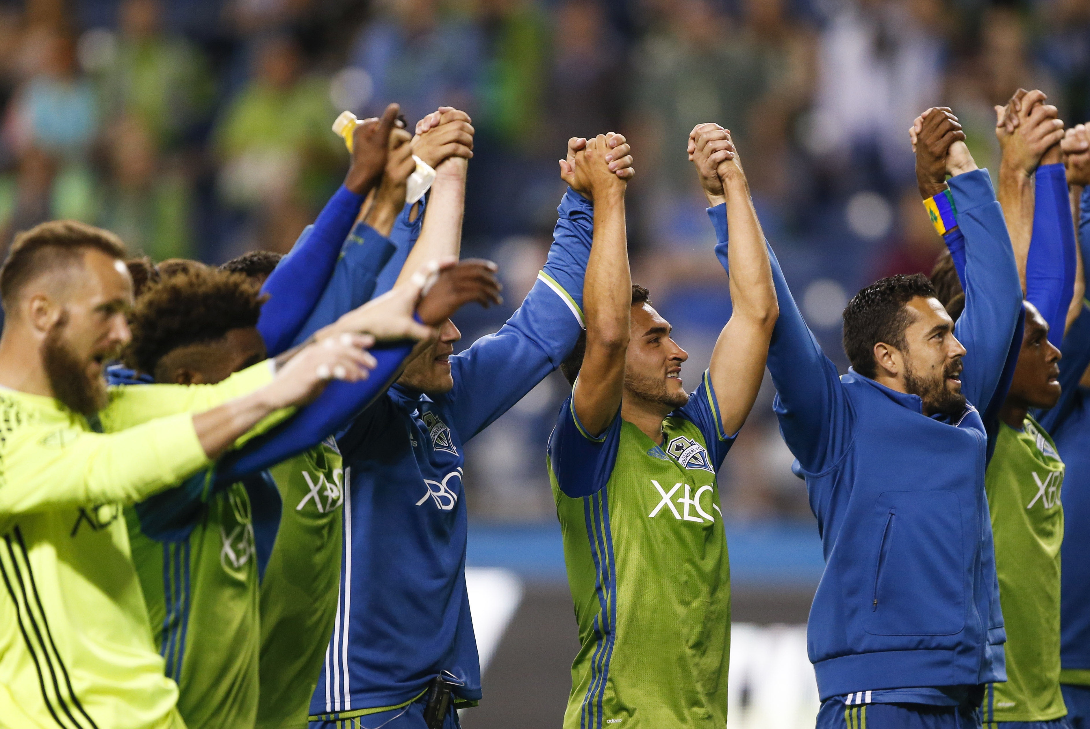Jul 13, 2016; Seattle, WA, USA; Seattle Sounders FC midfielder Cristian Roldan (middle-right) and defender Zach Scott (right) take a bow to the fans following a 5-0 victory against the FC Dallas at CenturyLink Field. Mandatory Credit: Joe Nicholson-USA TODAY Sports