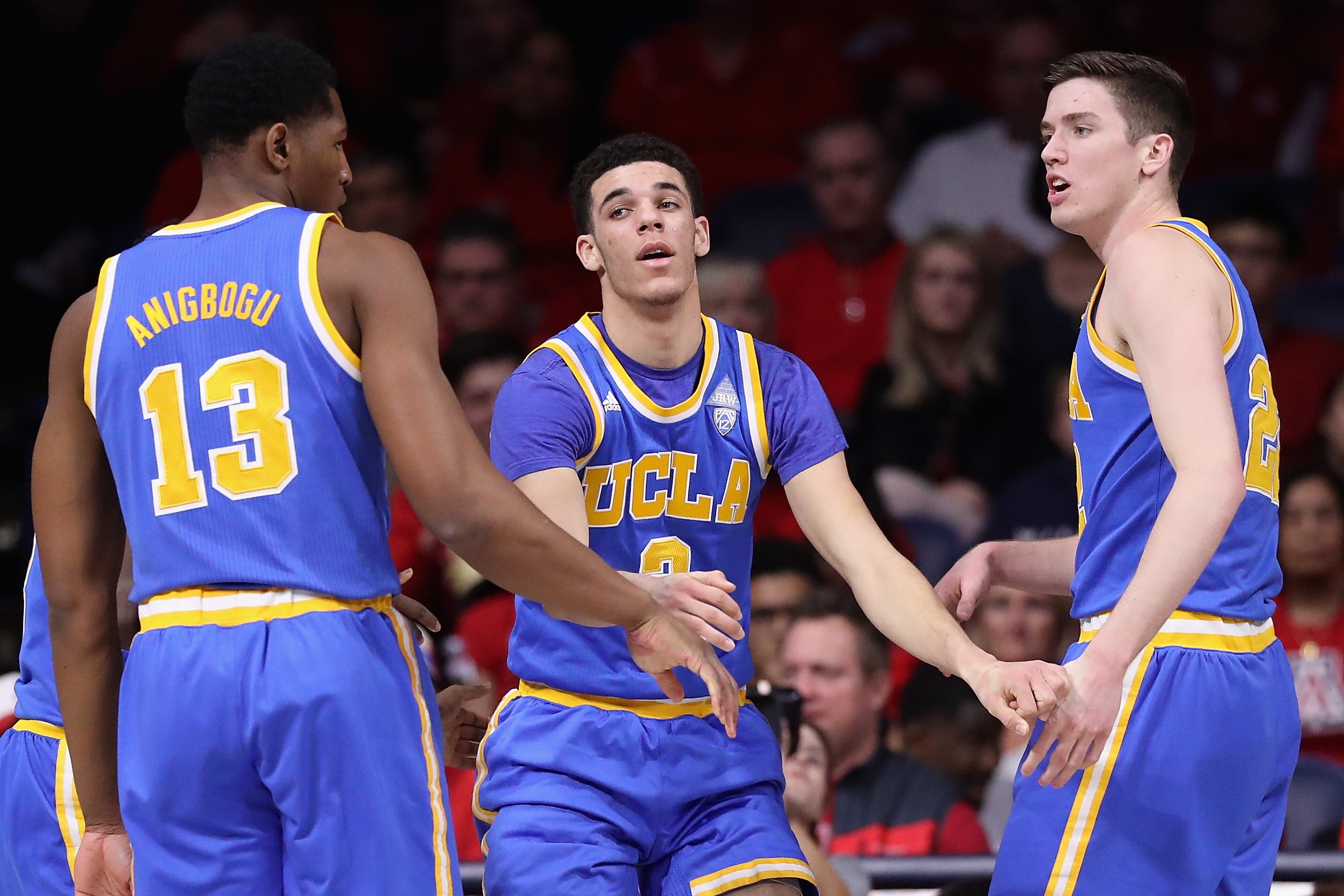 TUCSON, AZ - FEBRUARY 25: Lonzo Ball #2 of the UCLA Bruins is helped up by Ike Anigbogu #13 and TJ Leaf #22 after scoring against the Arizona Wildcats during the first half of the college basketball game at McKale Center on February 25, 2017 in Tucson, Arizona. (Photo by Christian Petersen/Getty Images)