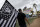 Matt Gutierrez carries a raiders flag by a sign welcoming visitors to Las Vegas, Monday, March 27, 2017, in Las Vegas. NFL team owners approved the move of the Raiders to Las Vegas in a vote at an NFL football annual meeting in Phoenix. (AP Photo/John Locher)