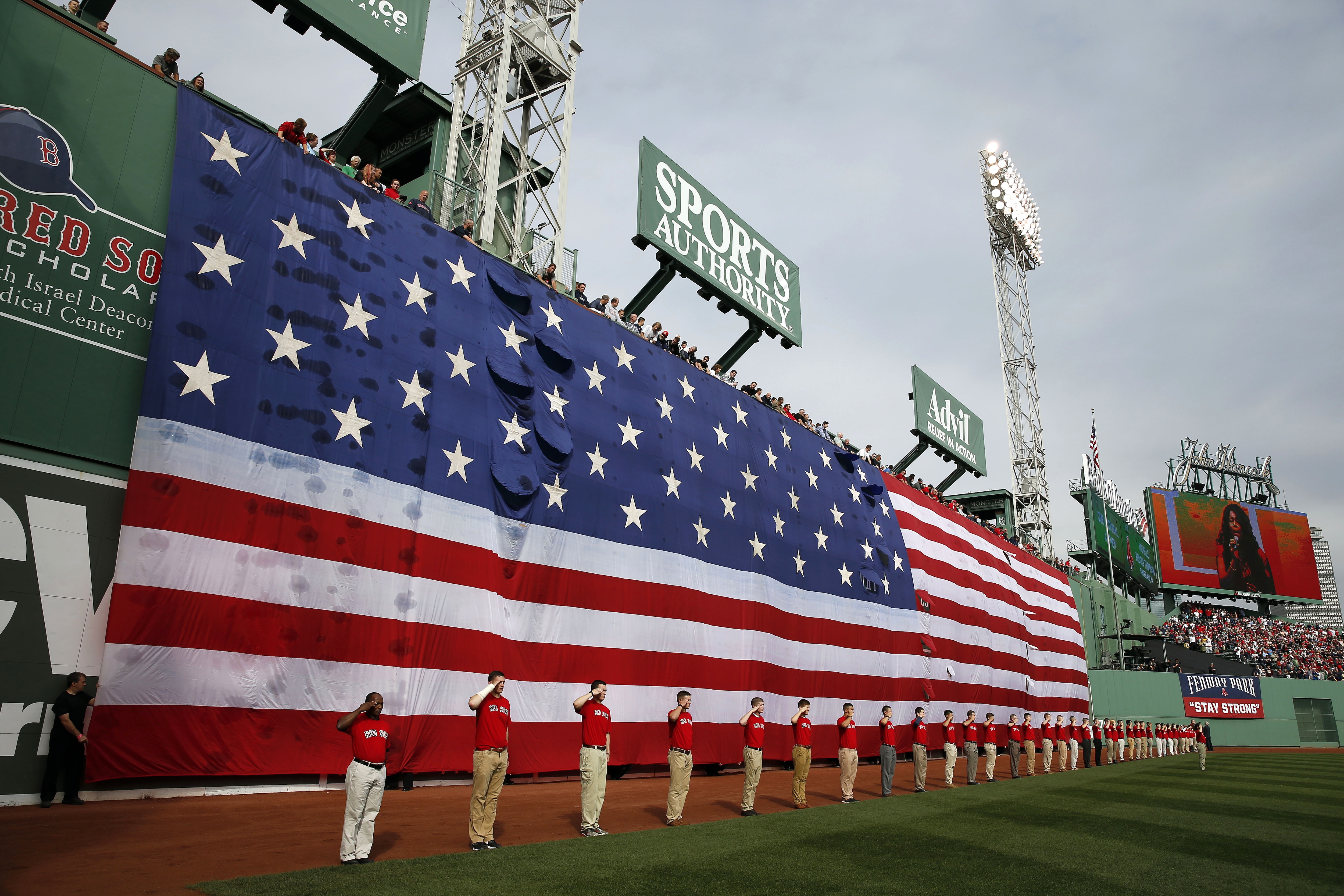 A giant flag covers the Green Monster left field wall during the national anthem before Game 1 of baseball's American League division series between the Boston Red Sox and the Tampa Bay Rays, Friday, Oct. 4, 2013, at Fenway Park in Boston. (AP Photo/Michael Dwyer)