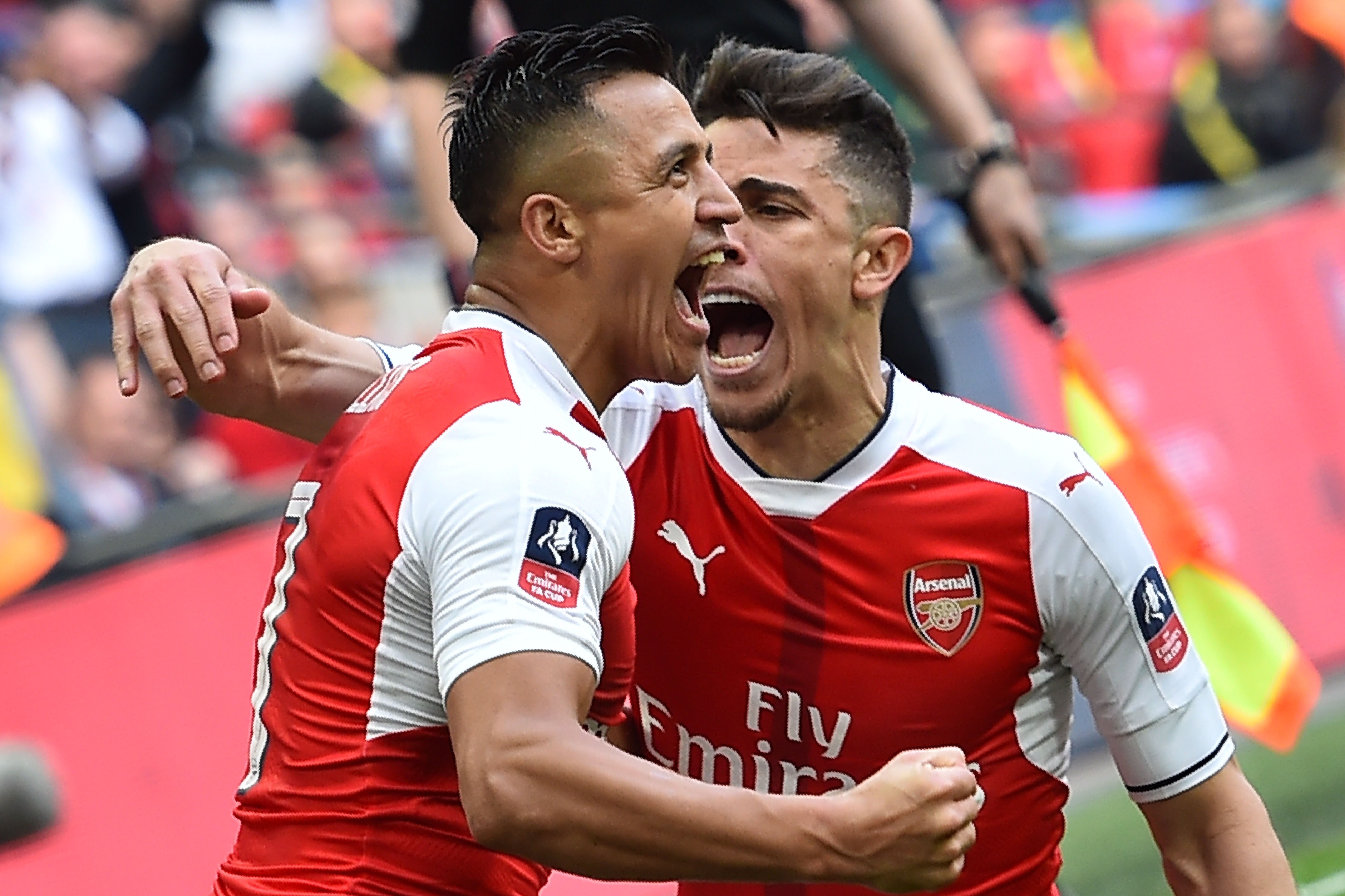 Arsenal's Chilean striker Alexis Sanchez (L) celebrates scoring their second goal with Arsenal's Brazilian defender Gabriel during the FA Cup semi-final football match between Arsenal and Manchester City at Wembley stadium in London on April 23, 2017. / AFP PHOTO / Glyn KIRK / NOT FOR MARKETING OR ADVERTISING USE / RESTRICTED TO EDITORIAL USE
(Photo credit should read GLYN KIRK/AFP/Getty Images)