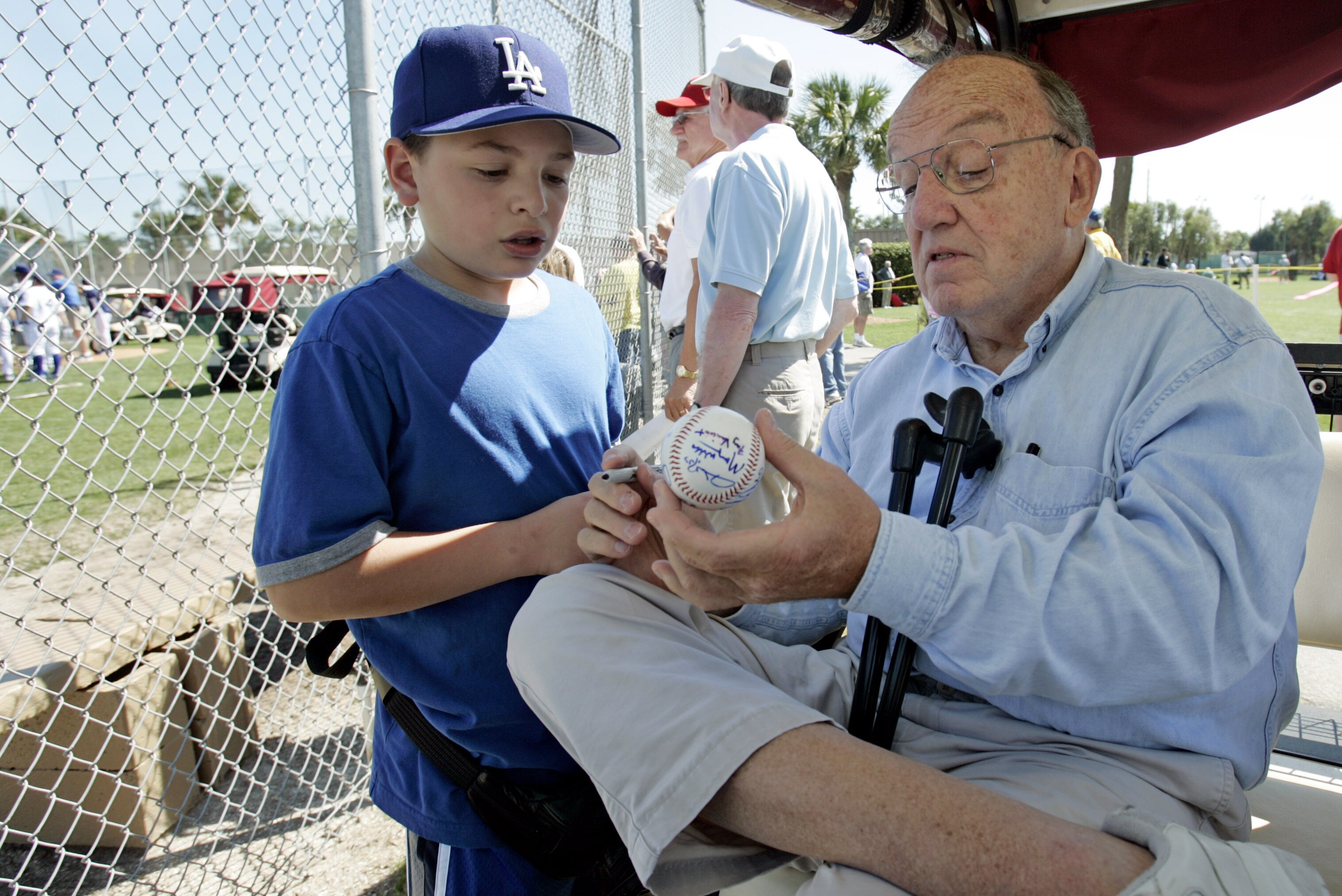 Former Major League Baseball Commissioner Fay Vincent signs an autograph for Louis Carrons, 12, of Rancho Cucamonga, Calif., during Los Angeles Dodgers baseball spring training in Vero Beach, Fla., Wednesday March 1, 2006. (AP Photo/Richard Drew)