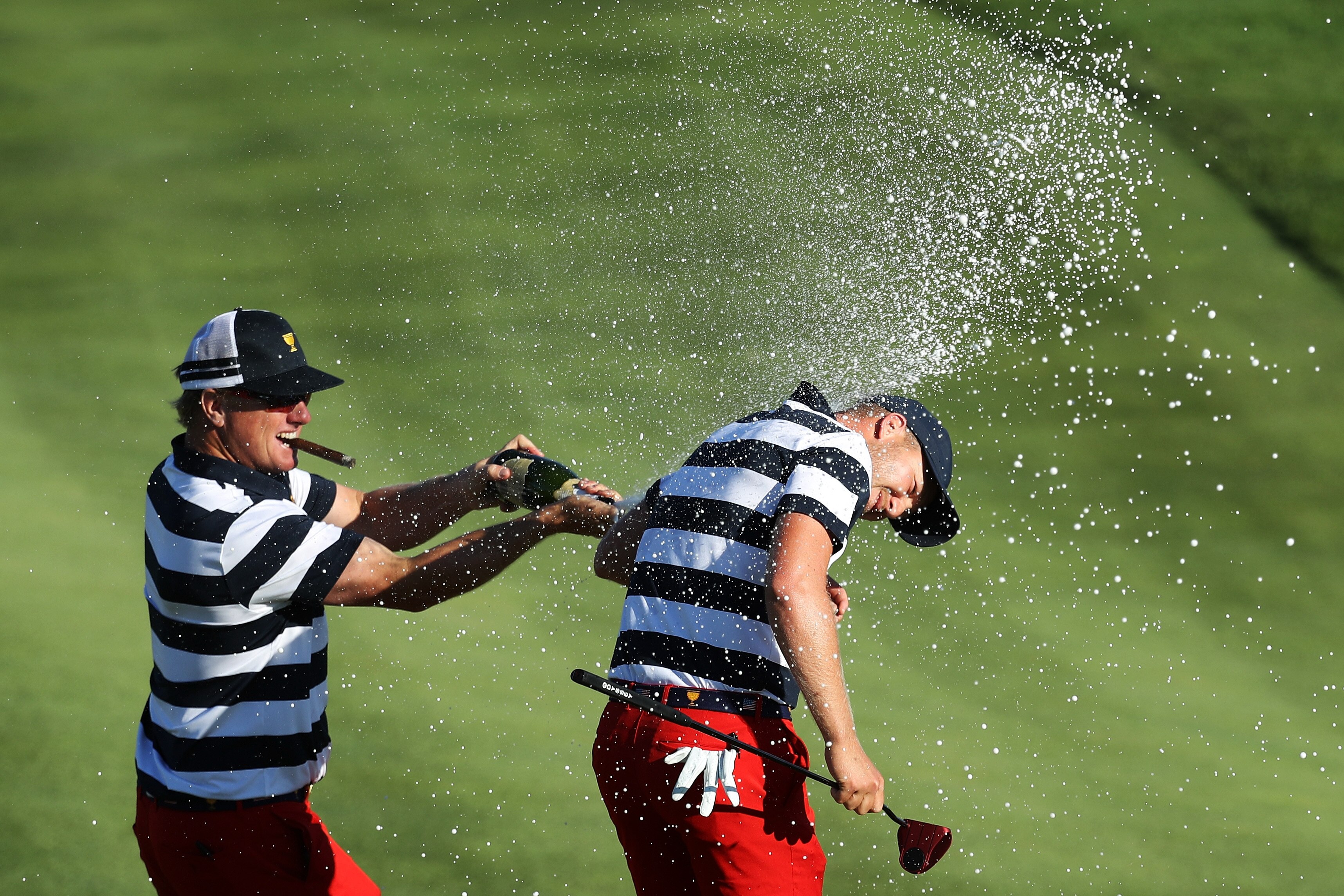 JERSEY CITY, NJ - OCTOBER 01: Charlie Hoffman sprays Daniel Berger of the U.S. Team with champagne after Berger defeated Si Woo Kim of South Korea and the International Team on the 17th hole 2&1 to give the U.S. Team the clinching point to win the Presidents Cup during Sunday singles matches at Liberty National Golf Club on October 1, 2017 in Jersey City, New Jersey. (Photo by Rob Carr/Getty Images)