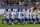 Players of Berlin kneel down prior to the German Bundesliga soccer match between Hertha BSC Berlin and FC Schalke 04 in Berlin, Germany, Saturday, Oct. 14, 2017. Hertha Berlin nodded to social struggles in the United States by kneeling before its Bundesliga game at home to Schalke on Saturday. Hertha’s starting lineup linked arms and took a knee on the pitch, while coaching staff, officials and substitutes took a knee off it. The action was intended to show solidarity with NFL players who have been demonstrating against discrimination in the US by kneeling, sitting or locking arms through the anthem before games.  (AP Photo/Michael Sohn)