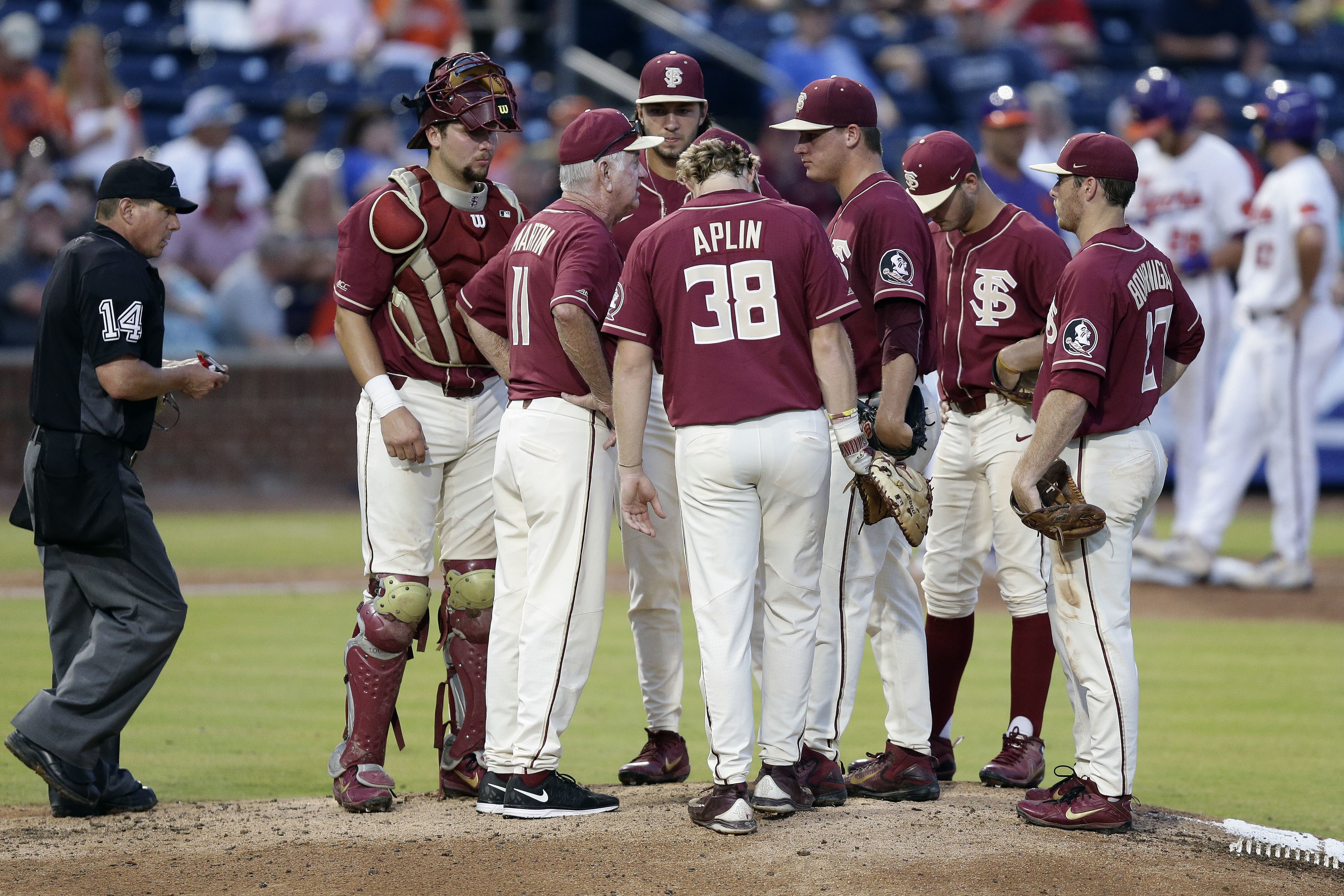 Florida State coach Mike Martin (11) speaks with his players during the sixth inning of an Atlantic Coast Conference NCAA college baseball tournament semifinal against Clemson in Durham, N.C., Saturday, May 26, 2018. (AP Photo/Gerry Broome)