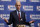 FILE - In this Dec. 13, 2017, file photo, NBA Commissioner Adam Silver gestures during a press conference in Indianapolis. The commission proposing reforms to college basketball wants 18-year-olds to be eligible again for the NBA draft, and the NBA Players Association would make that deal today. Change will take longer than that. NBA Commissioner Adam Silver senses the league’s age limit isn’t working. Requiring U.S. players to be 19 years old and one year removed from high school has sent many of them to a year of college they don’t want, and delayed the full-time basketball instruction pro teams prefer. But whether the league would agree to allow players to come straight from high school again, or want them to wait two years before becoming draft eligible, has been a sticking point practically since the age limited was enacted in 2005 and remains unclear now. (AP Photo/Michael Conroy, File)