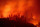 TOPSHOT - Flames from the Camp fire burn near a home atop a ridge near Big Bend, California, on November 10, 2018. - The death toll from the most destructive fire to hit California rose to 23 on November 10 as rescue workers recovered more bodies of people killed by the devastating blaze. Ten of the bodies were found in the town of Paradise while four were discovered in the Concow area, both in Butte County. (Photo by Josh Edelson / AFP)        (Photo credit should read JOSH EDELSON/AFP/Getty Images)