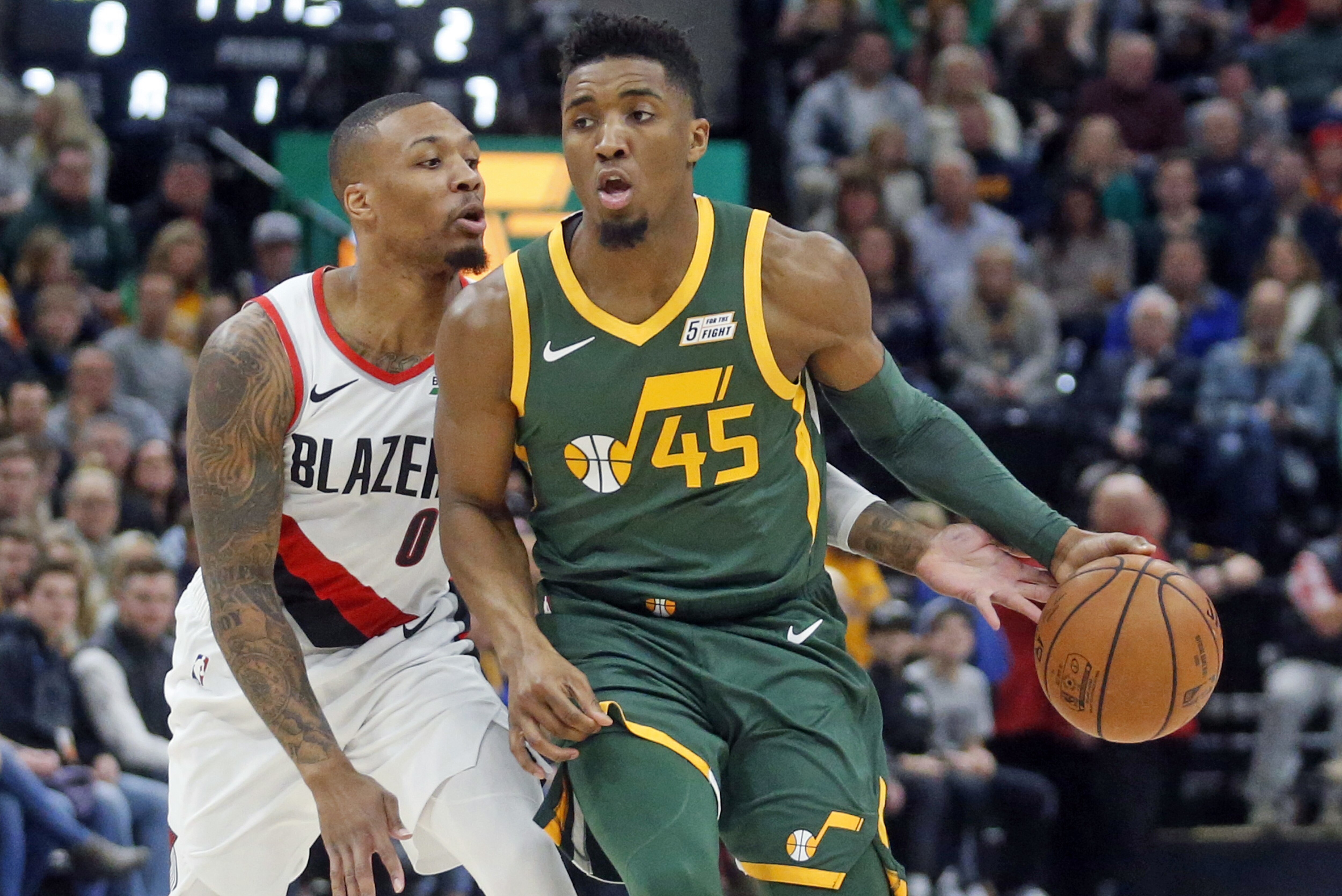 Portland Trail Blazers guard Damian Lillard (0) defends against Utah Jazz guard Donovan Mitchell (45) during the first half of an NBA basketball game Tuesday, Dec. 25, 2018, in Salt Lake City. (AP Photo/Rick Bowmer)