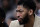 New Orleans Pelicans forward Anthony Davis watches from the bench in street clothes during the first half of the team's NBA basketball game against the San Antonio Spurs in San Antonio, Saturday, Feb. 2, 2019. (AP Photo/Eric Gay)