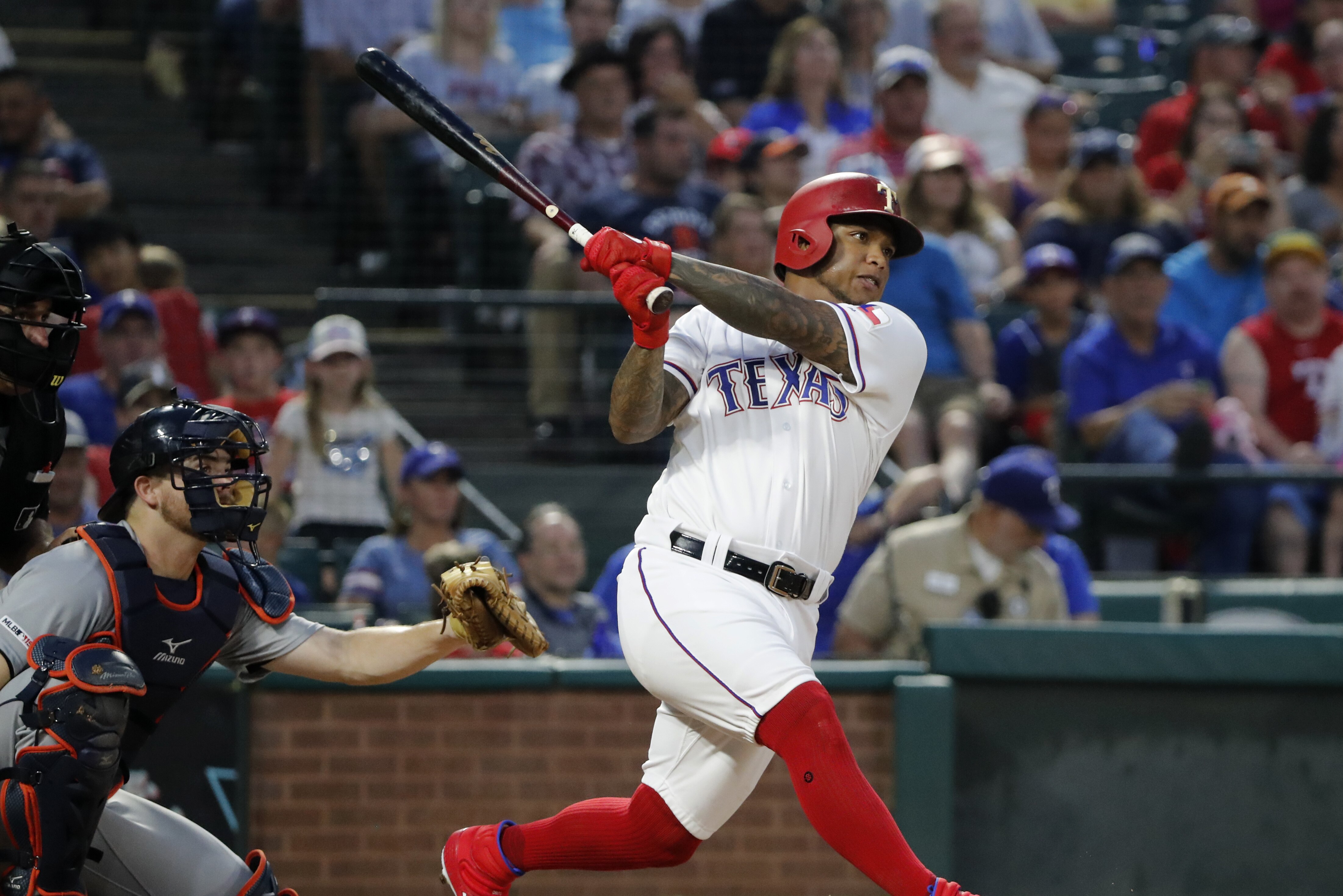 Texas Rangers' Willie Calhoun follows through on a solo home run as Detroit Tigers' Jake Rogers, left, watches during the fourth inning of a baseball game in Arlington, Texas, Saturday, Aug. 3, 2019. (AP Photo/Tony Gutierrez)