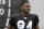 Oakland Raiders' Antonio Brown jogs onto the field before stretching during NFL football practice in Alameda, Calif., Tuesday, Aug. 20, 2019. (AP Photo/Jeff Chiu)