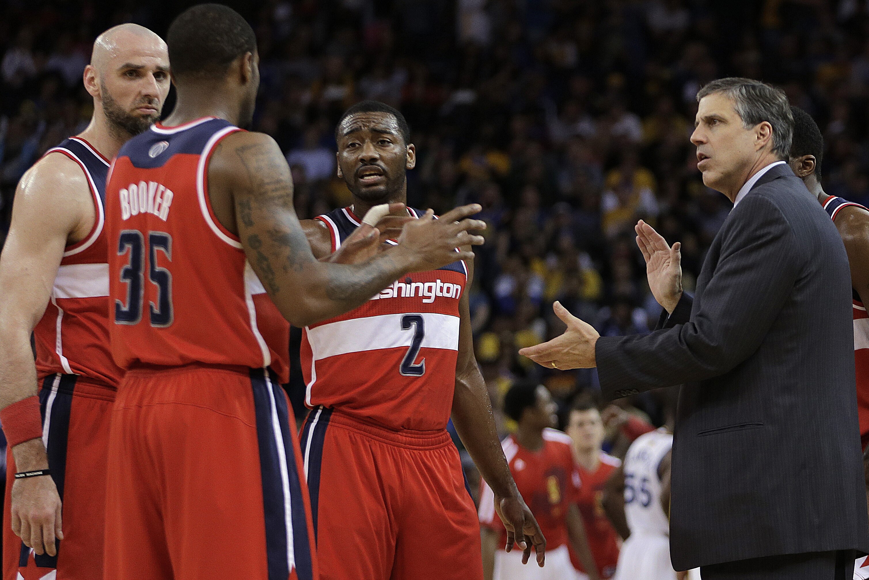 Washington Wizards coach Randy Wittman, right, speaks with Trevor Booker (35), Marcin Gortat, left, and John Wall (2) during the first half of an NBA basketball game against the Golden State Warriors, Tuesday, Jan. 28, 2014, in Oakland, Calif. (AP Photo/Ben Margot)