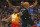 Toronto Raptors center Serge Ibaka, rear, defends against Utah Jazz guard Donovan Mitchell (45) who goes to the basket in the second half during an NBA basketball game Monday, March 9, 2020, in Salt Lake City. (AP Photo/Rick Bowmer)