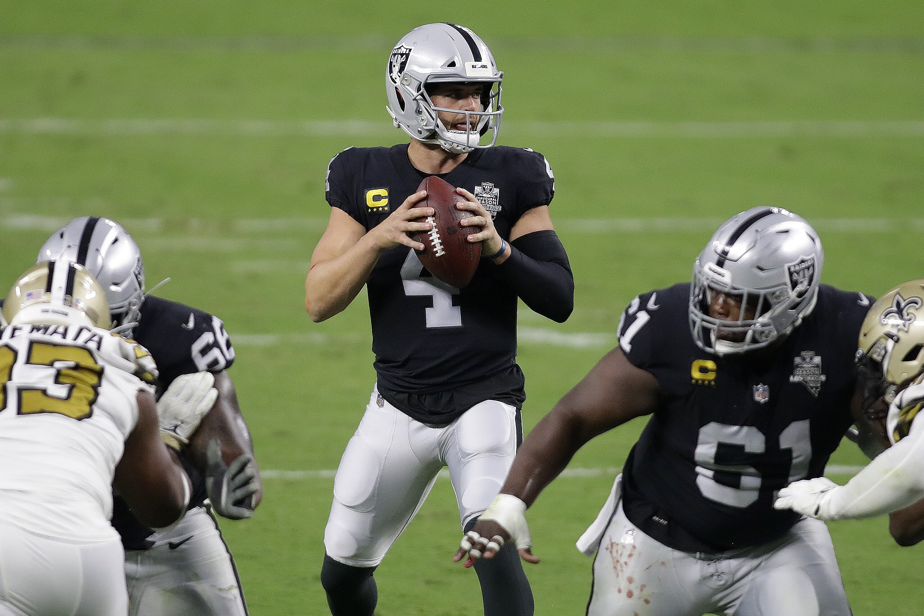 Las Vegas Raiders quarterback Derek Carr (4) drops back to pass against the New Orleans Saints during the first half of an NFL football game, Monday, Sept. 21, 2020, in Las Vegas. (AP Photo/Isaac Brekken)