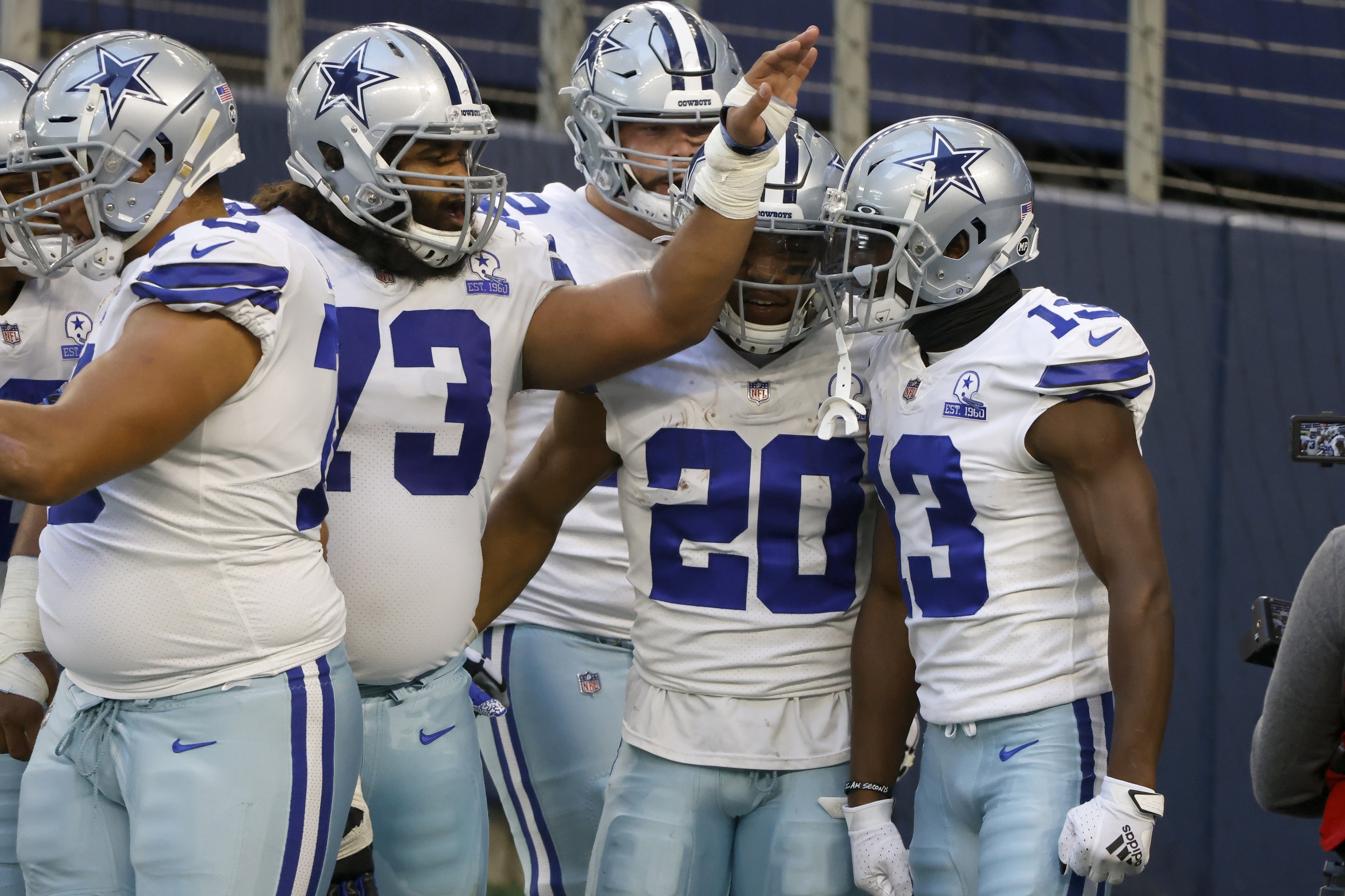 Dallas Cowboys' Joe Looney (73), and Tony Pollard (20) celebrate with Michael Gallup (13) after his touchdown catch in the first half of an NFL football game against the Philadelphia Eagles in Arlington, Texas, Sunday, Dec. 27. 2020. (AP Photo/Ron Jenkins)