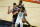 Utah Jazz guard Donovan Mitchell (45) looks to pass around Phoenix Suns guard Devin Booker during the second half of an NBA basketball game, Wednesday, April 7, 2021, in Phoenix. (AP Photo/Matt York)